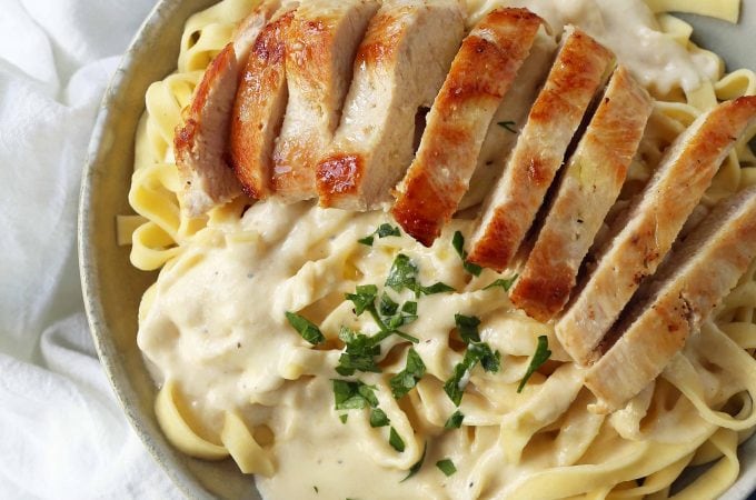 Chicken Fettucine Alfredo. Creamy parmesan cream sauce tossed with fettuccine pasta and topped with sauteed chicken. How to make the best chicken fettuccine alfredo. www.modernhoney.com #fettuccinealfredo #chickenfettuccinealfredo #pasta