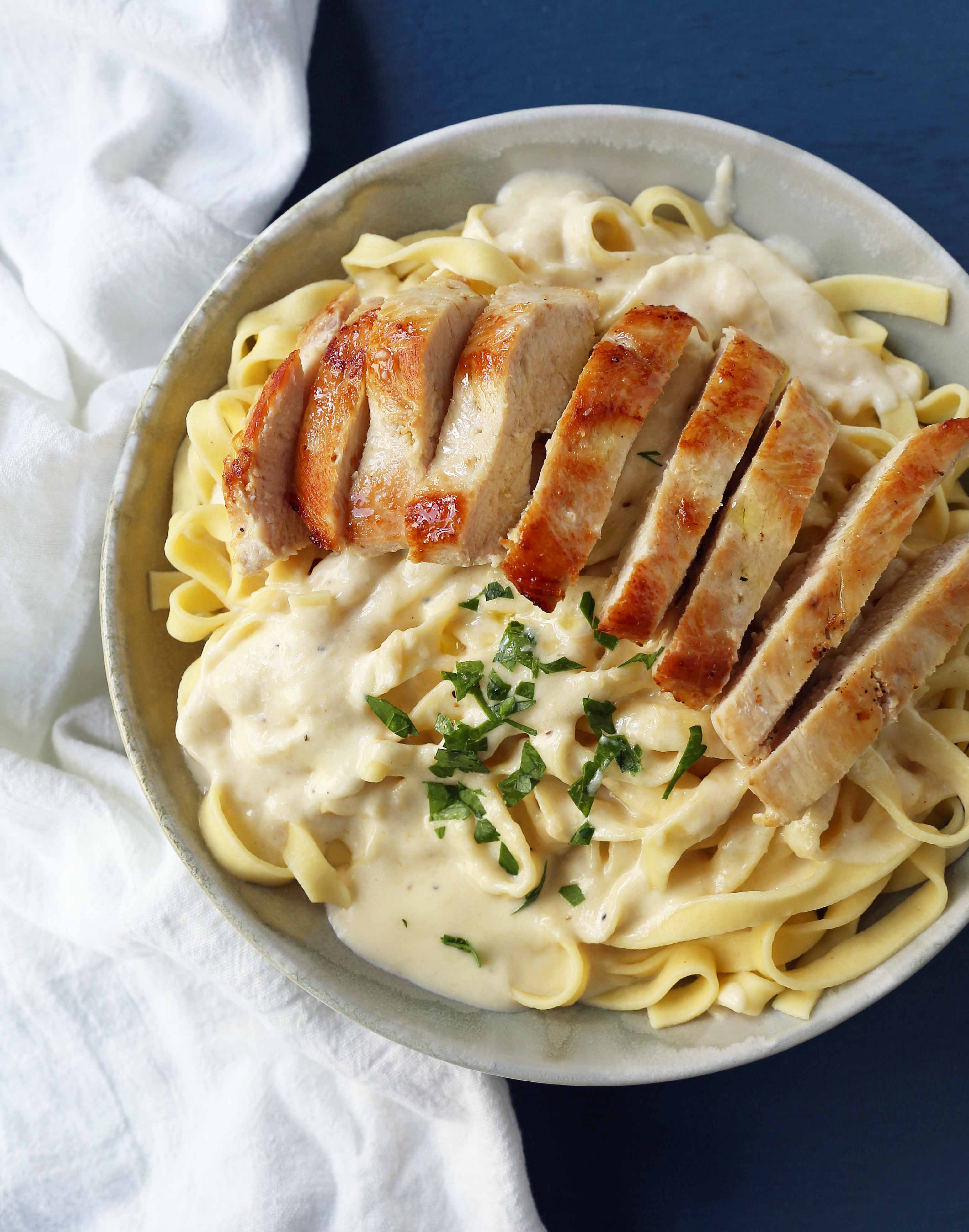 Chicken Fettucine Alfredo. Creamy parmesan cream sauce tossed with fettuccine pasta and topped with sauteed chicken. How to make the best chicken fettuccine alfredo. www.modernhoney.com #fettuccinealfredo #chickenfettuccinealfredo #pasta