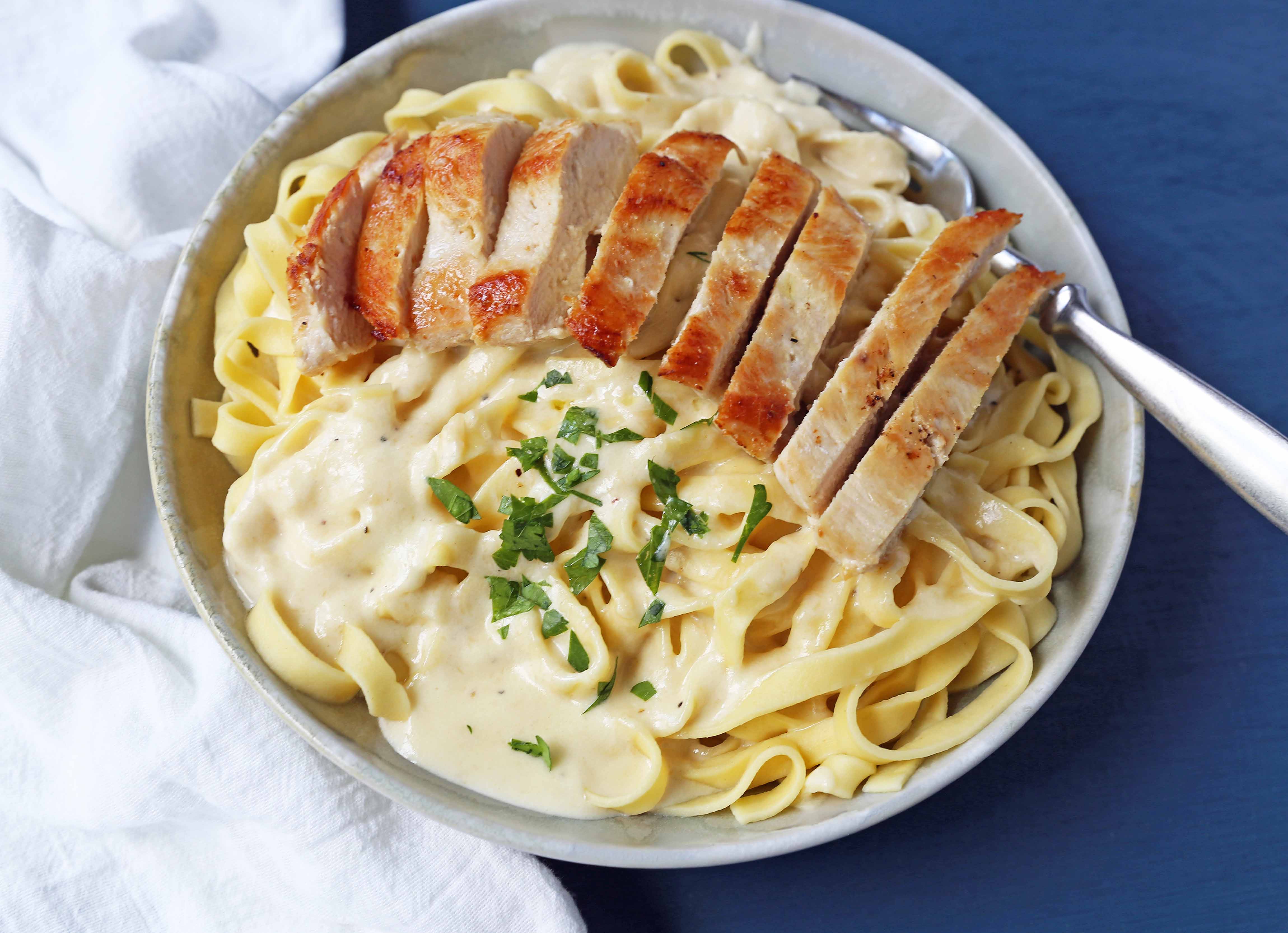 Chicken Fettucine Alfredo. Creamy parmesan cream sauce tossed with fettuccine pasta and topped with sauteed chicken. How to make the best chicken fettuccine alfredo. www.modernhoney.com #fettuccinealfredo #chickenfettuccinealfredo #pasta