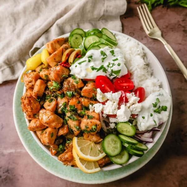 How to make the Best Greek Chicken Bowls. Grilled Greek Lemon Chicken, cucumber, tomatoes, red onion, kalamata olives, feta cheese, and homemade tzatziki sauce all in one bowl. A high-protein and low-carb meal! 