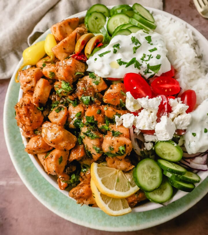 How to make the Best Greek Chicken Bowls. Grilled Greek Lemon Chicken, cucumber, tomatoes, red onion, kalamata olives, feta cheese, and homemade tzatziki sauce all in one bowl. A high-protein and low-carb meal! 