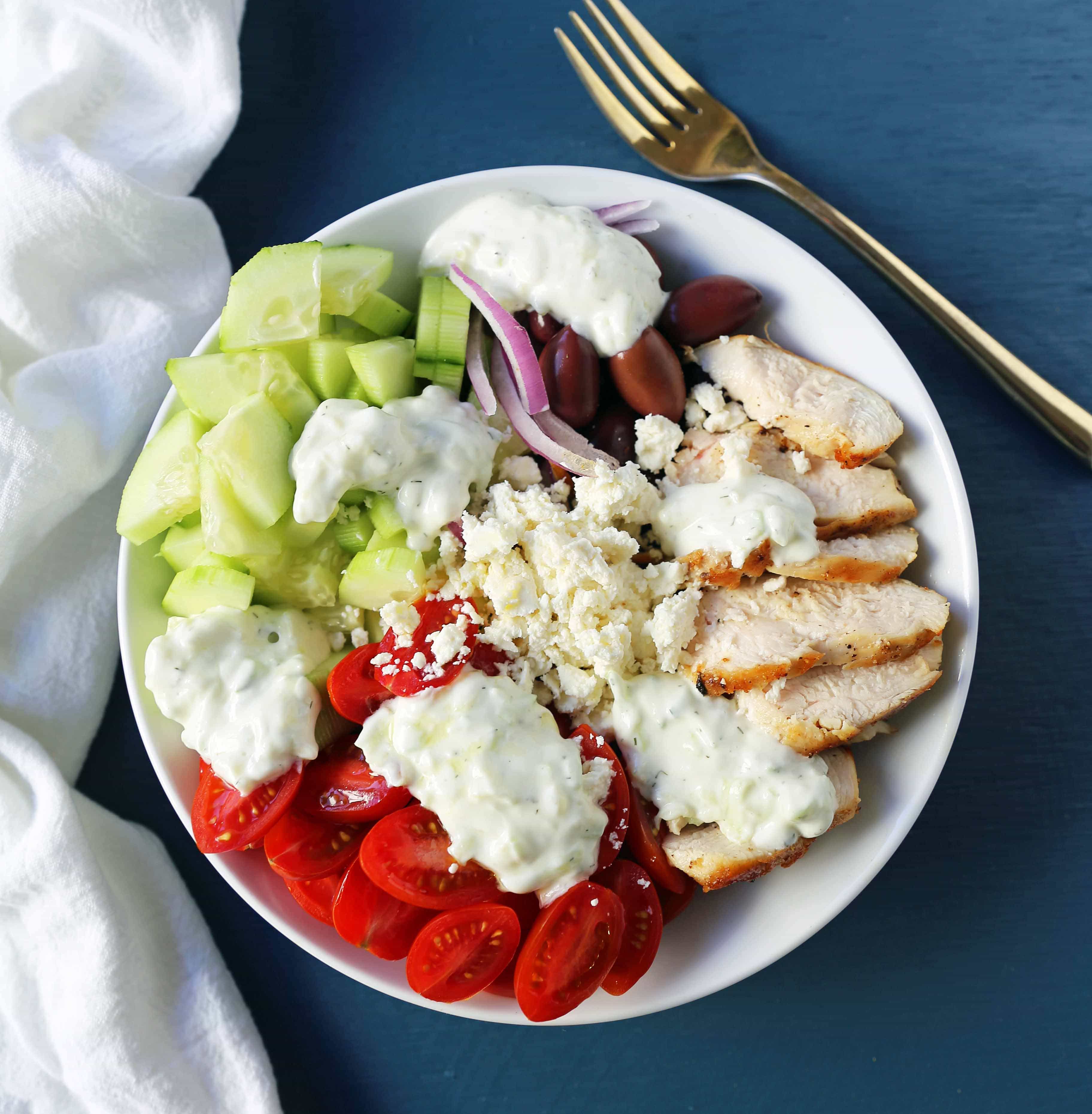 Greek Chicken Bowls. Grilled Greek Lemon Chicken, cucumber, tomatoes, red onion, kalamata olives, feta cheese, and homemade tzatziki sauce all in one bowl. A high-protein and low carb meal! www.modernhoney.com #greekchickenbowls #greekchickenbowl #greekfood #glutenfree
