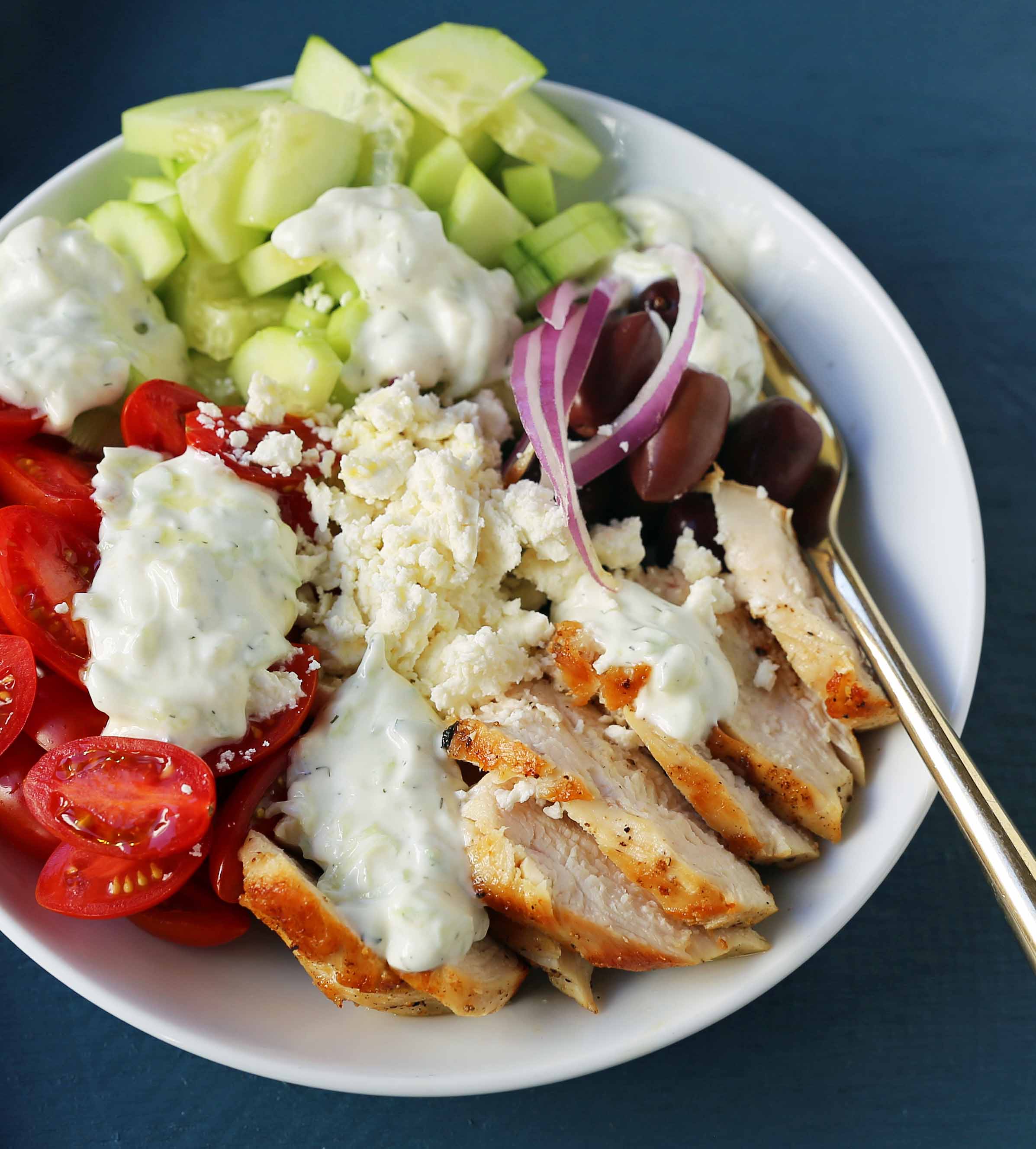 Greek Chicken Bowls. Grilled Greek Lemon Chicken, cucumber, tomatoes, red onion, kalamata olives, feta cheese, and homemade tzatziki sauce all in one bowl. A high-protein and low carb meal! www.modernhoney.com #greekchickenbowls #greekchickenbowl #greekfood #glutenfree