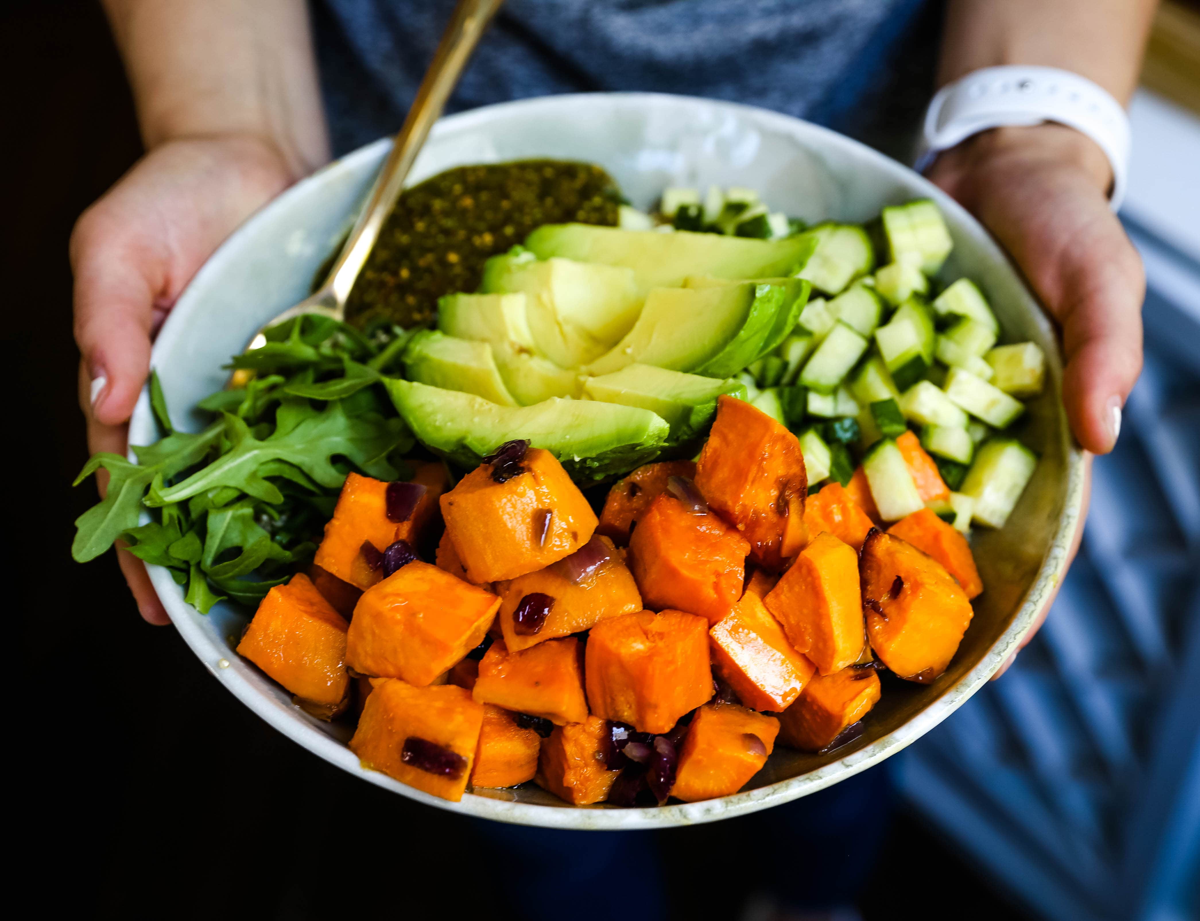 Buddha Bowl with Pistachio Pesto A healthy vegan bowl made with roasted sweet potatoes, onions, fresh avocado, cucumbers, arugula, quinoa, and homemade pistachio pesto. www.modernhoney.com #buddhabowl #vegan #vegetarian #flowerchild 