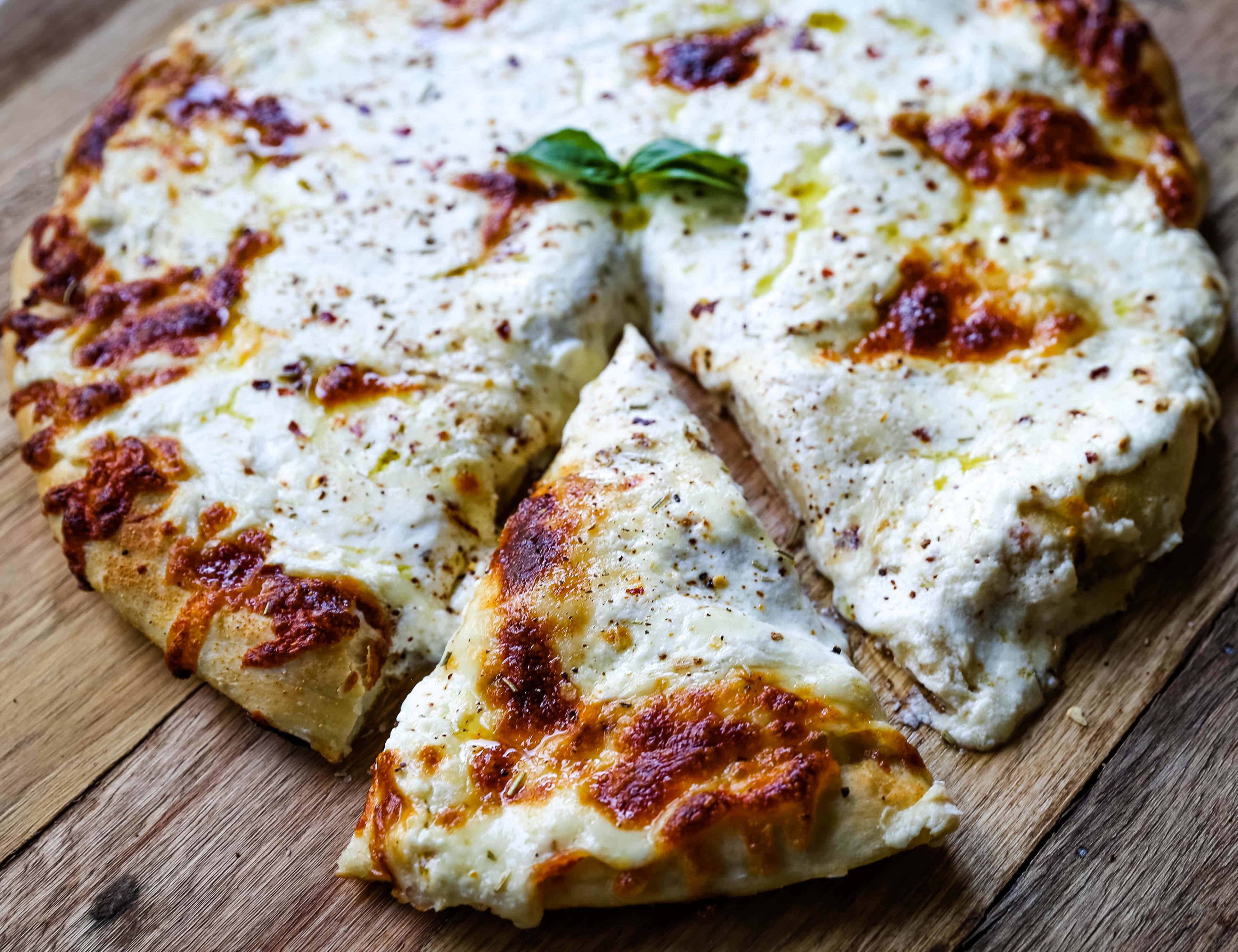 The Best 3-Cheese White Pizza A New-York Style white pizza with drizzled olive oil, mozzarella, parmesan, and ricotta cheese with Italian herbs. www.modernhoney.com #pizzabianca #whitepizza #pizza 