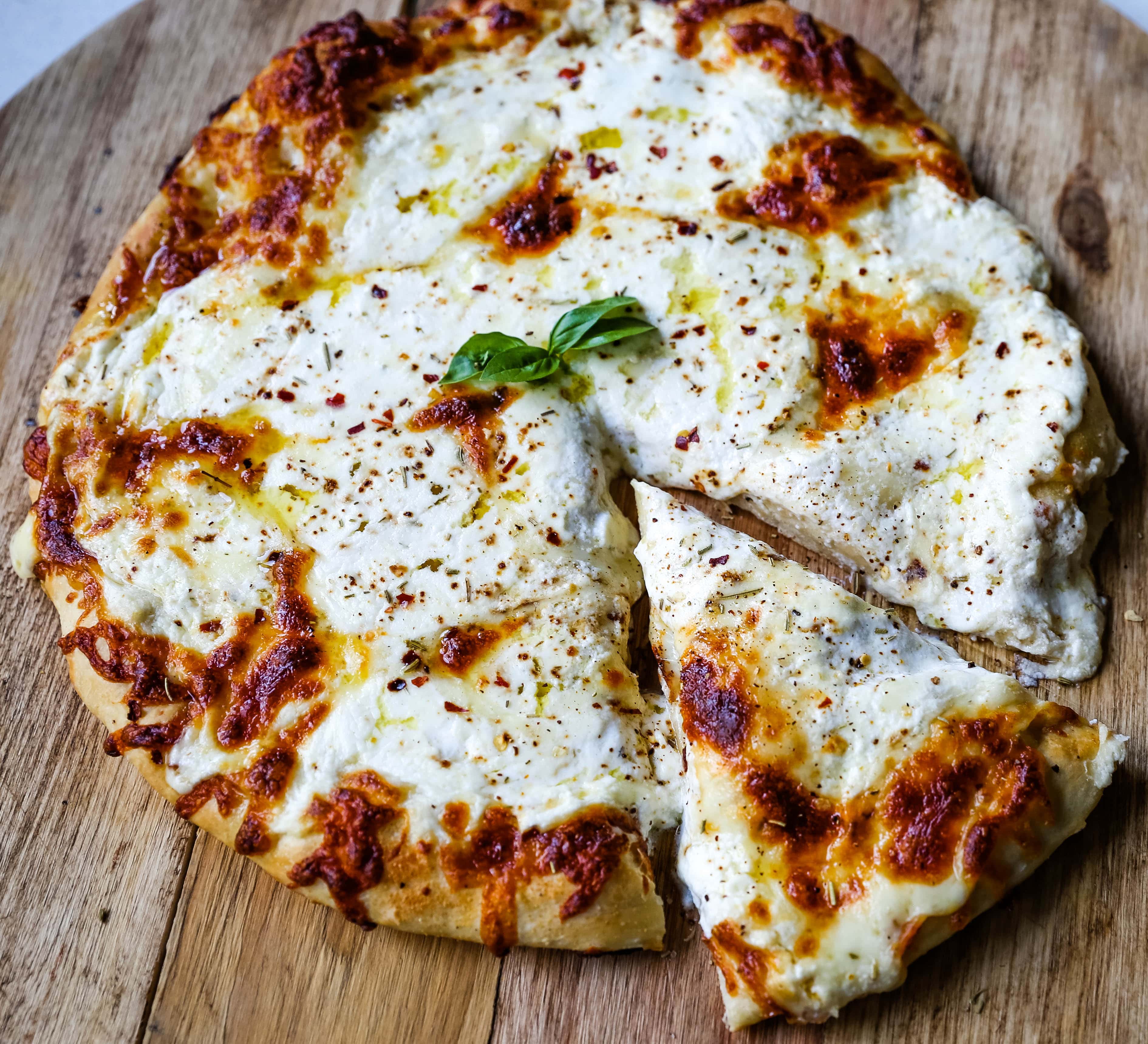 The Best 3-Cheese White Pizza A New-York Style white pizza with drizzled olive oil, mozzarella, parmesan, and ricotta cheese with Italian herbs. www.modernhoney.com #pizzabianca #whitepizza #pizza 