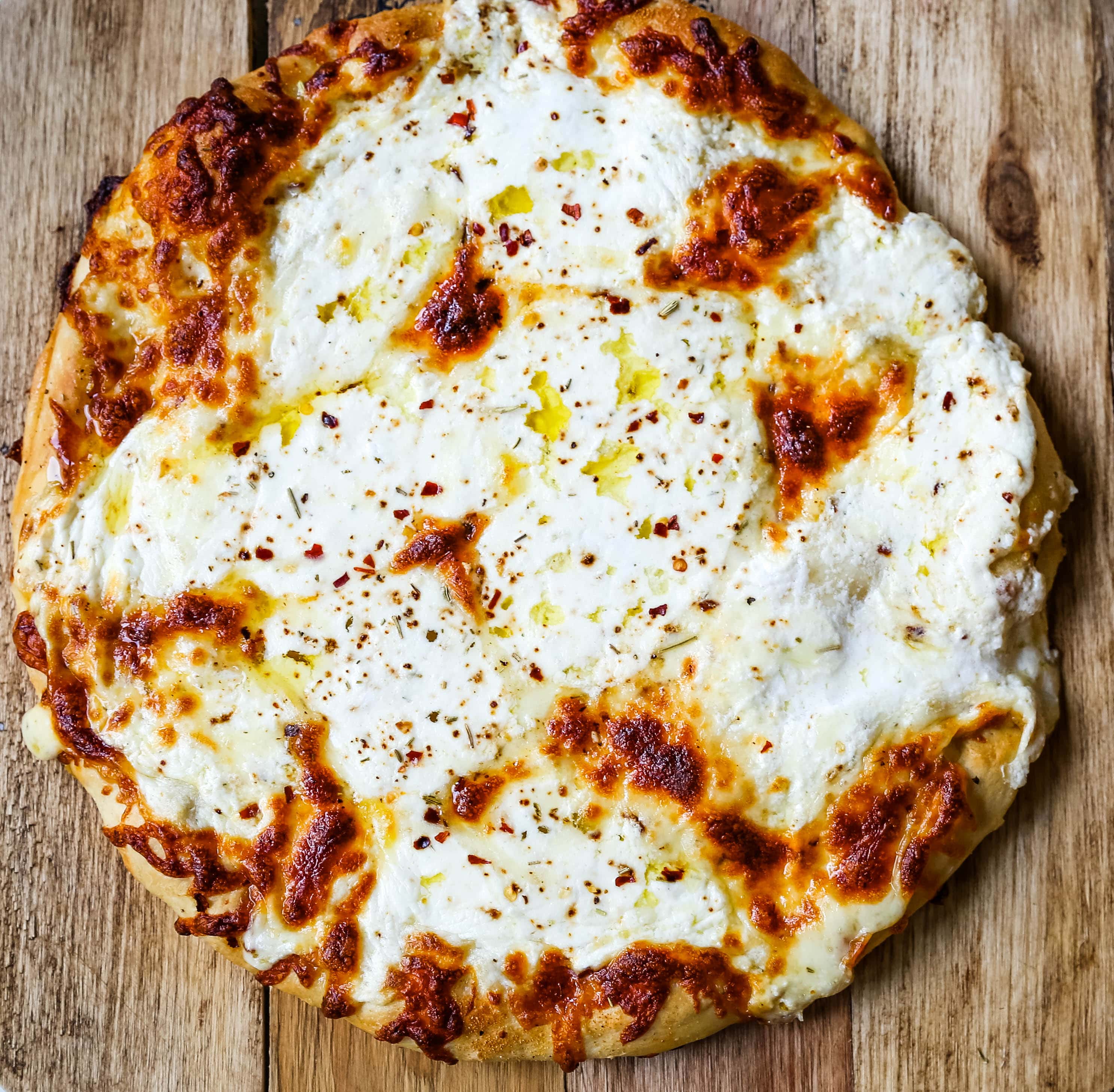 The Best 3-Cheese White Pizza A New-York Style white pizza with drizzled olive oil, mozzarella, parmesan, and ricotta cheese with Italian herbs. www.modernhoney.com #pizzabianca #whitepizza #pizza 