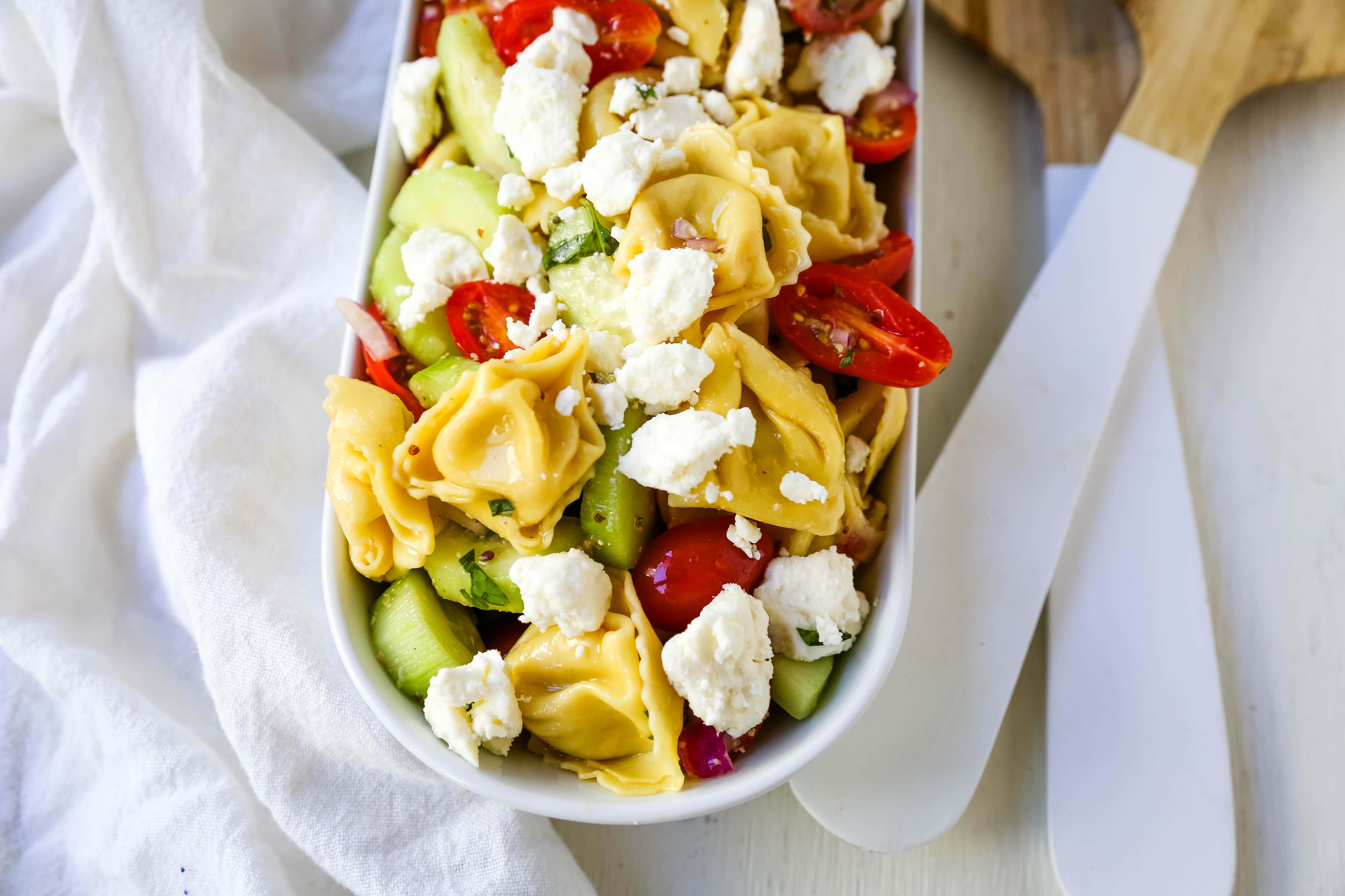 Greek Tortellini Pasta Salad. Cheese Tortellini Pasta tossed with fresh tomatoes, cucumbers, red onion, feta cheese, in a homemade Greek dressing. www.modernhoney.com #sidedish #pastasalad #salad #potluck