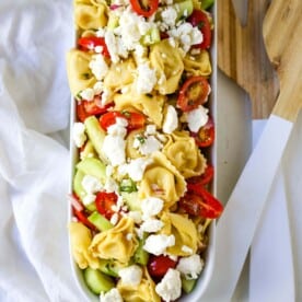 Greek Tortellini Pasta Salad. Cheese Tortellini Pasta tossed with fresh tomatoes, cucumbers, red onion, feta cheese, in a homemade Greek dressing. www.modernhoney.com #sidedish #pastasalad #salad #potluck