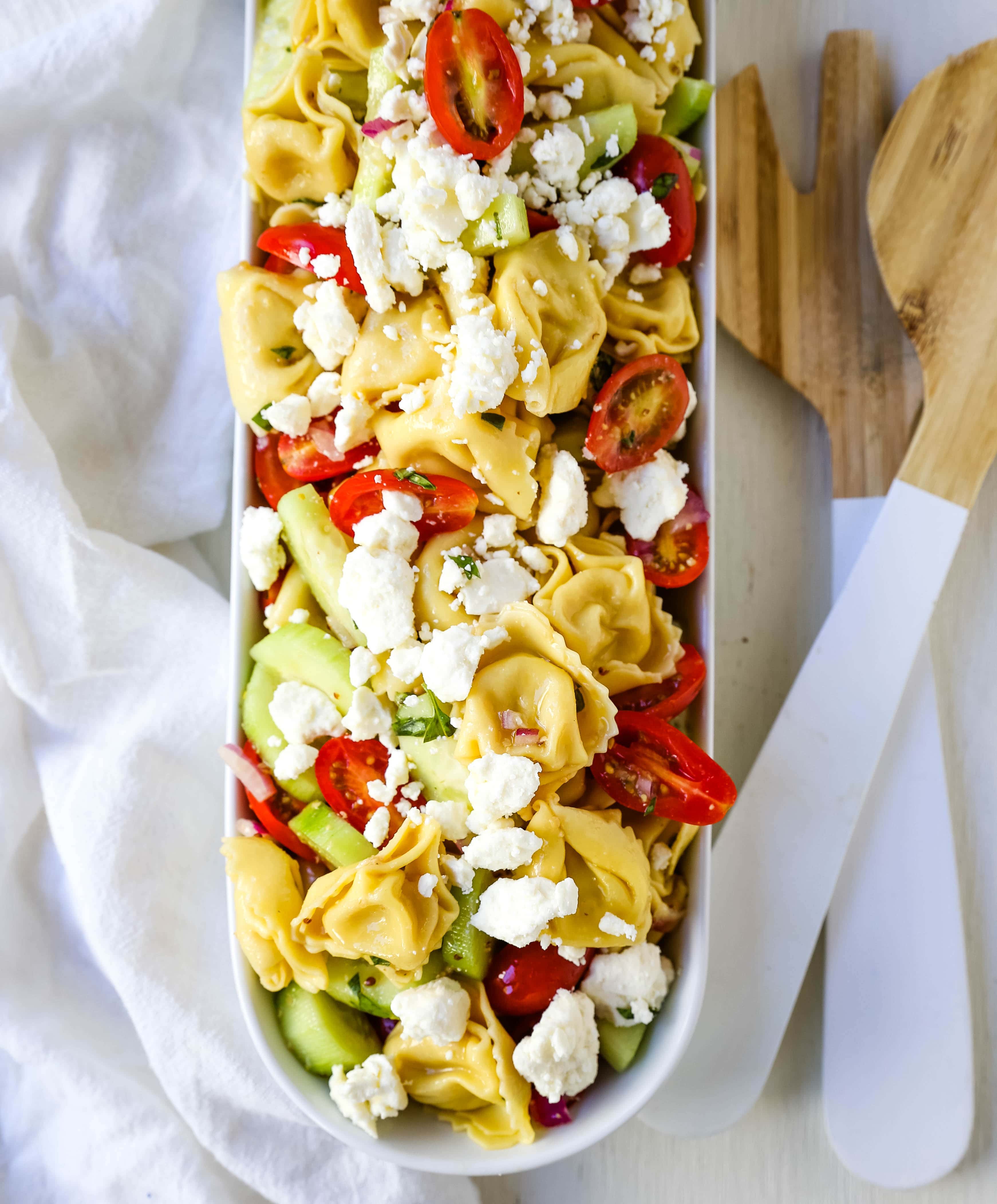 Greek Tortellini Pasta Salad. Cheese Tortellini Pasta tossed with fresh tomatoes, cucumbers, red onion, feta cheese, in a homemade Greek dressing. www.modernhoney.com #sidedish #pastasalad #salad #potluck