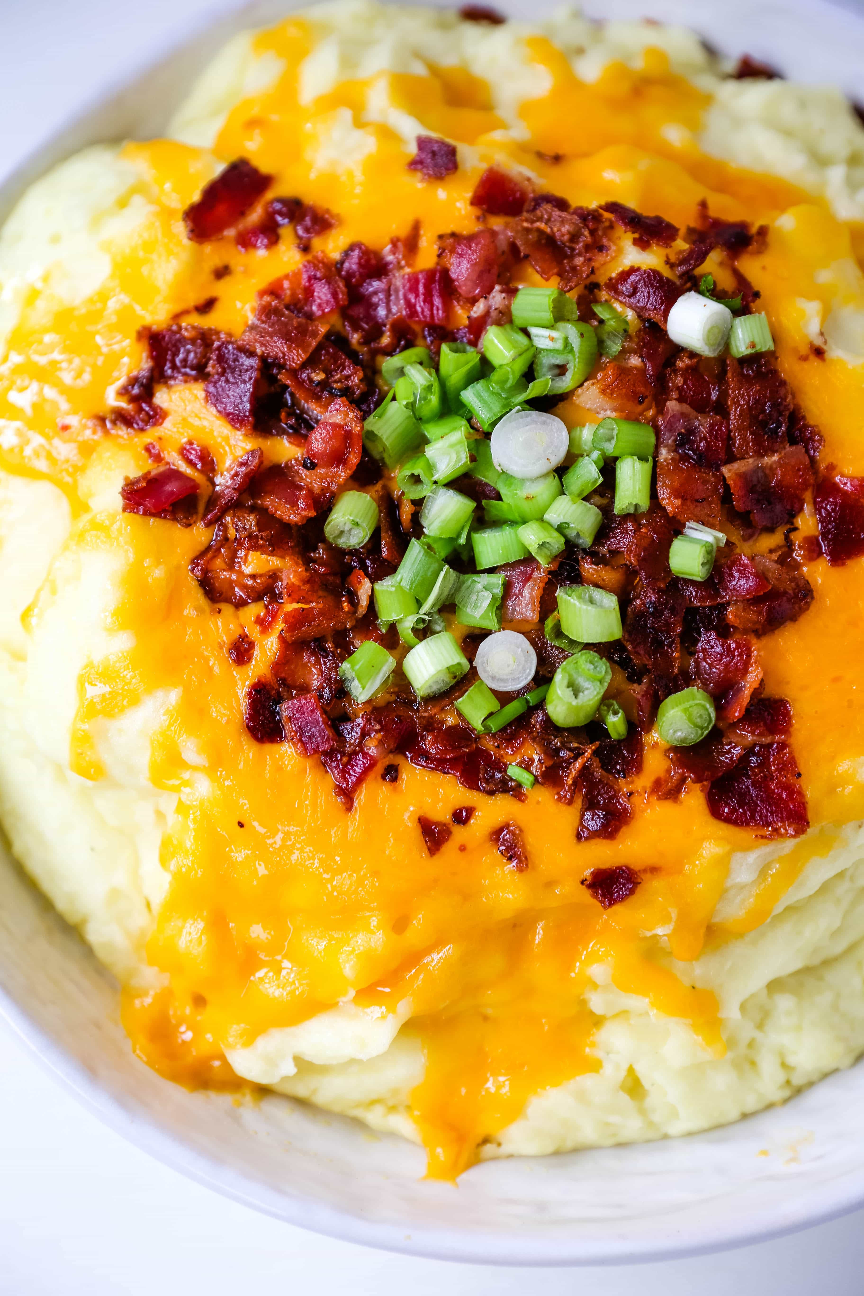 Loaded Mashed Potatoes. Creamy buttery mashed potatoes with sour cream, cheddar cheese, crispy bacon, and green onions. The perfect flavorful side dish that everyone loves! #mashedpotatoes #loadedmashedpotatoes #potatoes #sidedish