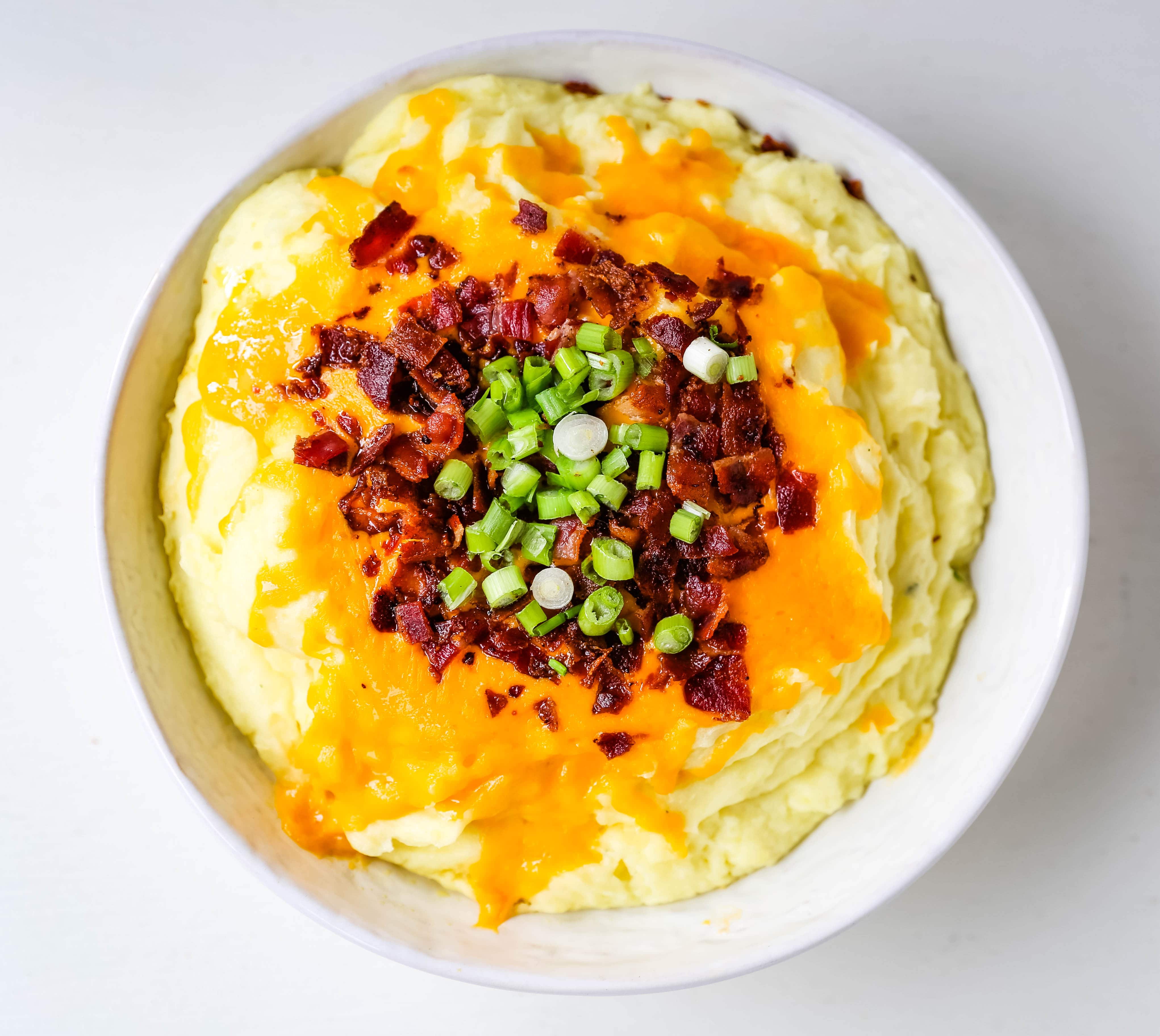 Loaded Mashed Potatoes. Creamy buttery mashed potatoes with sour cream, cheddar cheese, crispy bacon, and green onions. The perfect flavorful side dish that everyone loves! #mashedpotatoes #loadedmashedpotatoes #potatoes #sidedish