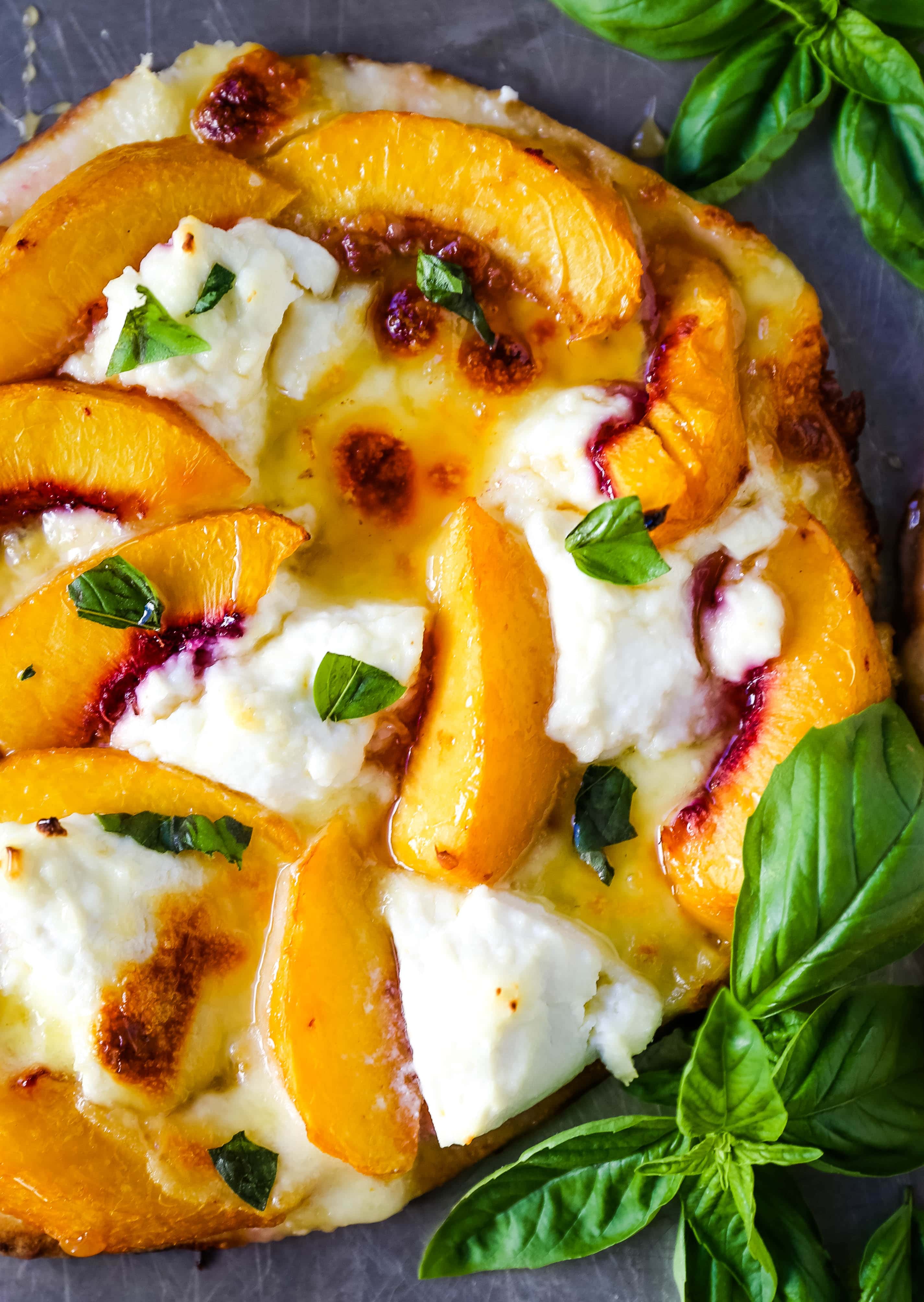 Peach Basil Mozzarella Flatbread Fresh peaches, basil ribbons, ricotta cheese, a drizzle of honey, fresh mozzarella all on a buttery flatbread. The perfect summer pizza!  www.modernhoney.com #peachpizza #flatbread #peachflatbread #summerpizza #peachrecipes