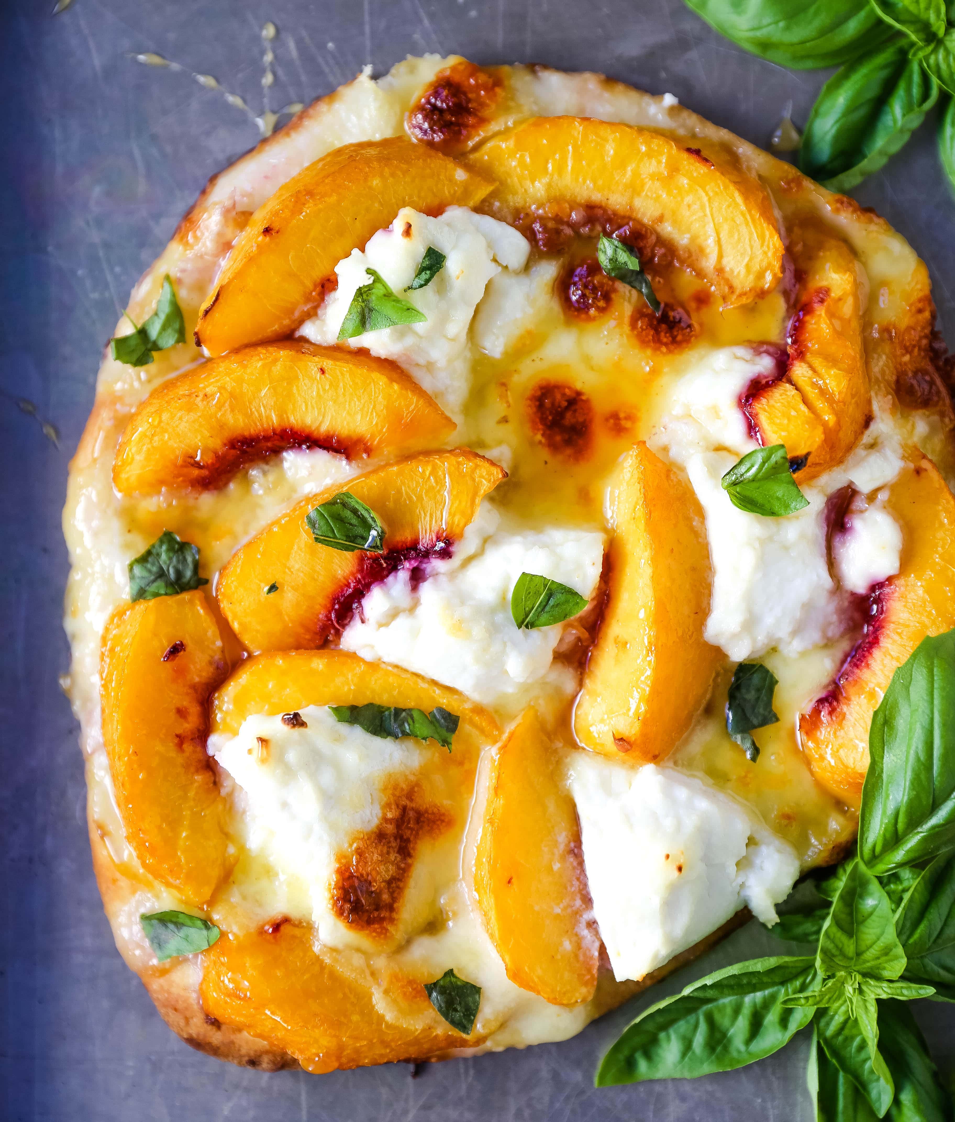 Peach Basil Mozzarella Flatbread Fresh peaches, basil ribbons, ricotta cheese, a drizzle of honey, fresh mozzarella all on a buttery flatbread. The perfect summer pizza!  www.modernhoney.com #peachpizza #flatbread #peachflatbread #summerpizza #peachrecipes