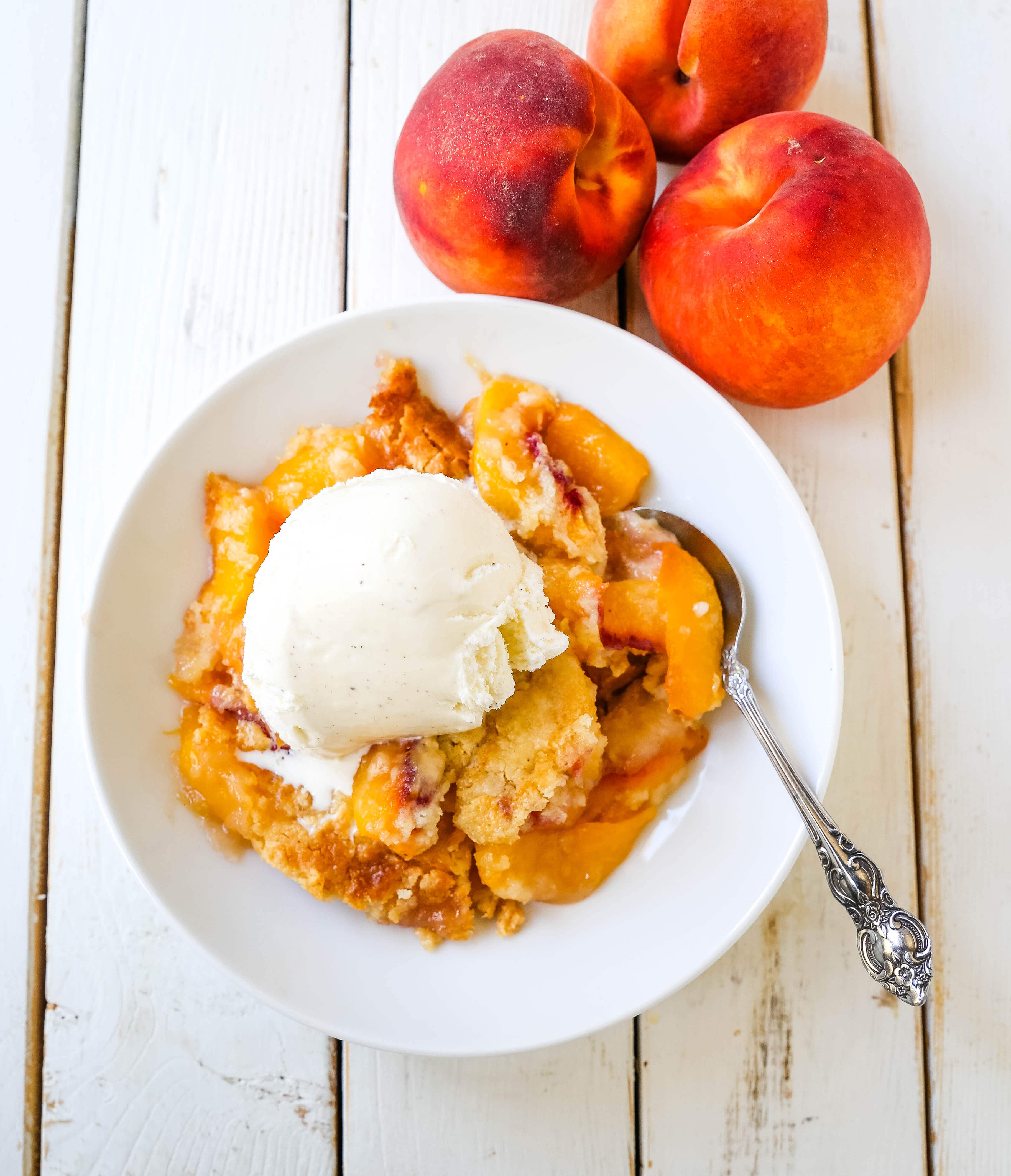 Peach Dump Cake The easiest 4-ingredient peach dessert. Fresh peaches, a touch of sugar, French vanilla cake mix, and butter all baked until golden and topped with vanilla ice cream. The simplest peach cobbler dessert recipe! www.modernhoney.com #peach #peaches #peachdesserts #peachcobbler #peachdumpcake