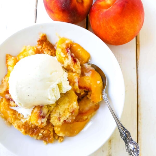 Peach Dump Cake The easiest 4-ingredient peach dessert. Fresh peaches, a touch of sugar, French vanilla cake mix, and butter all baked until golden and topped with vanilla ice cream. The simplest peach cobbler dessert recipe! www.modernhoney.com #peach #peaches #peachdesserts #peachcobbler #peachdumpcake