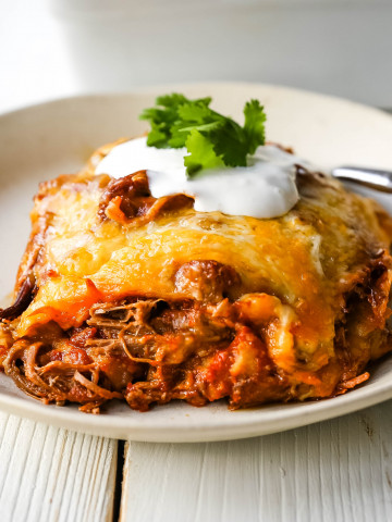 Stacked Beef Enchiladas. Mexican seasoned shredded beef enchiladas with melted cheese, corn tortillas, and homemade enchilada sauce. An easy beef enchilada casserole! #mexican #mexicanfood #enchiladas #beefenchiladas