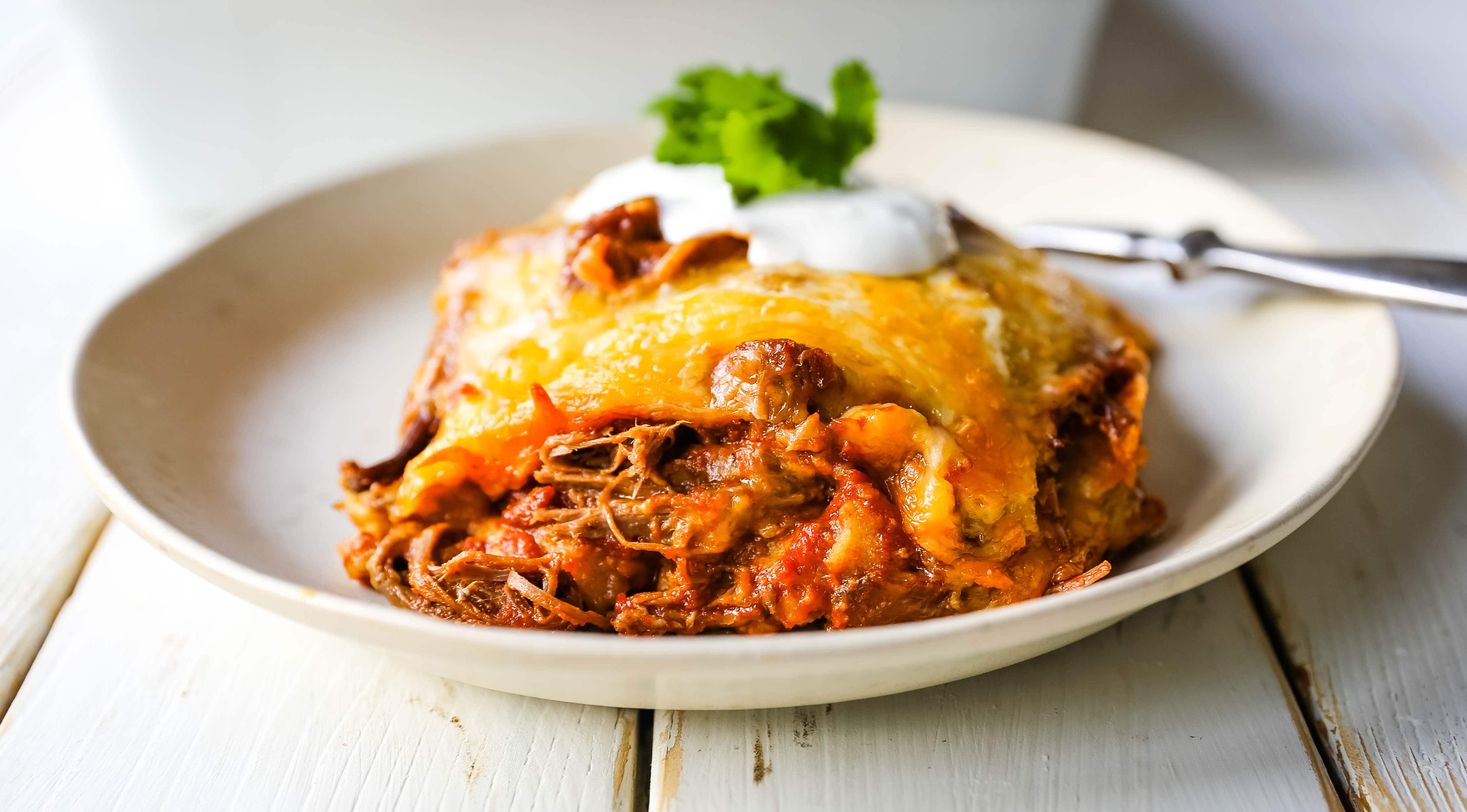 Stacked Beef Enchiladas. Mexican seasoned shredded beef enchiladas with melted cheese, corn tortillas, and homemade enchilada sauce. An easy beef enchilada casserole! #mexican #mexicanfood #enchiladas #beefenchiladas