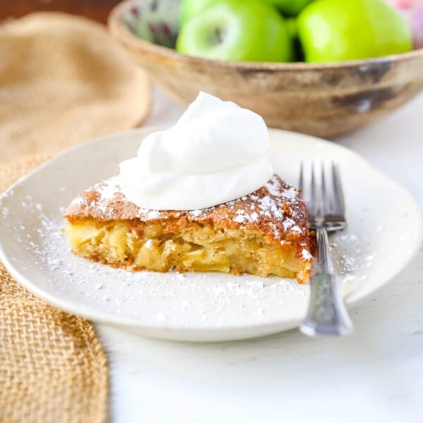 French Apple Cake A simple French buttery cake made with sweet apples and topped with freshly whipped cream. www.modernhoney.com #frenchapplecake #applecake #frenchcake #dessert #appledessert