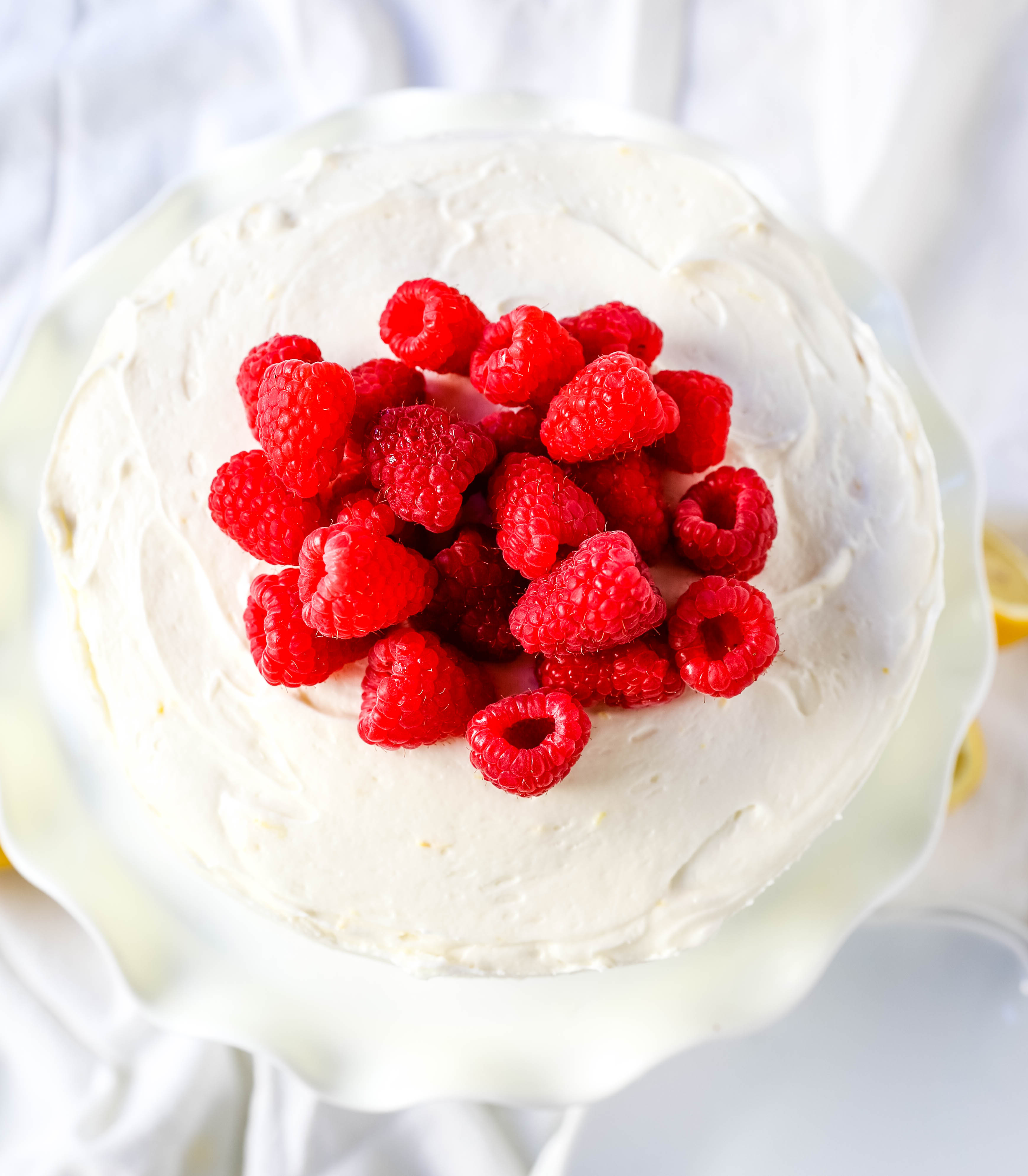 The Best Lemon Raspberry Cake. A light and fluffy lemon cake with fresh raspberries and a fresh lemon cream cheese frosting. A sweet and tangy lemon berry cake! #lemoncake #cake #lemonraspberrycake