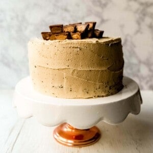 Chocolate Cake with Peanut Butter Frosting A moist 5-Star Rated Chocolate Cake with Creamy Peanut Butter Frosting topped with Peanut Butter Cups. www.modernhoney.com #peanutbutter #chocolatepeanutbuttercake #chocolatecake