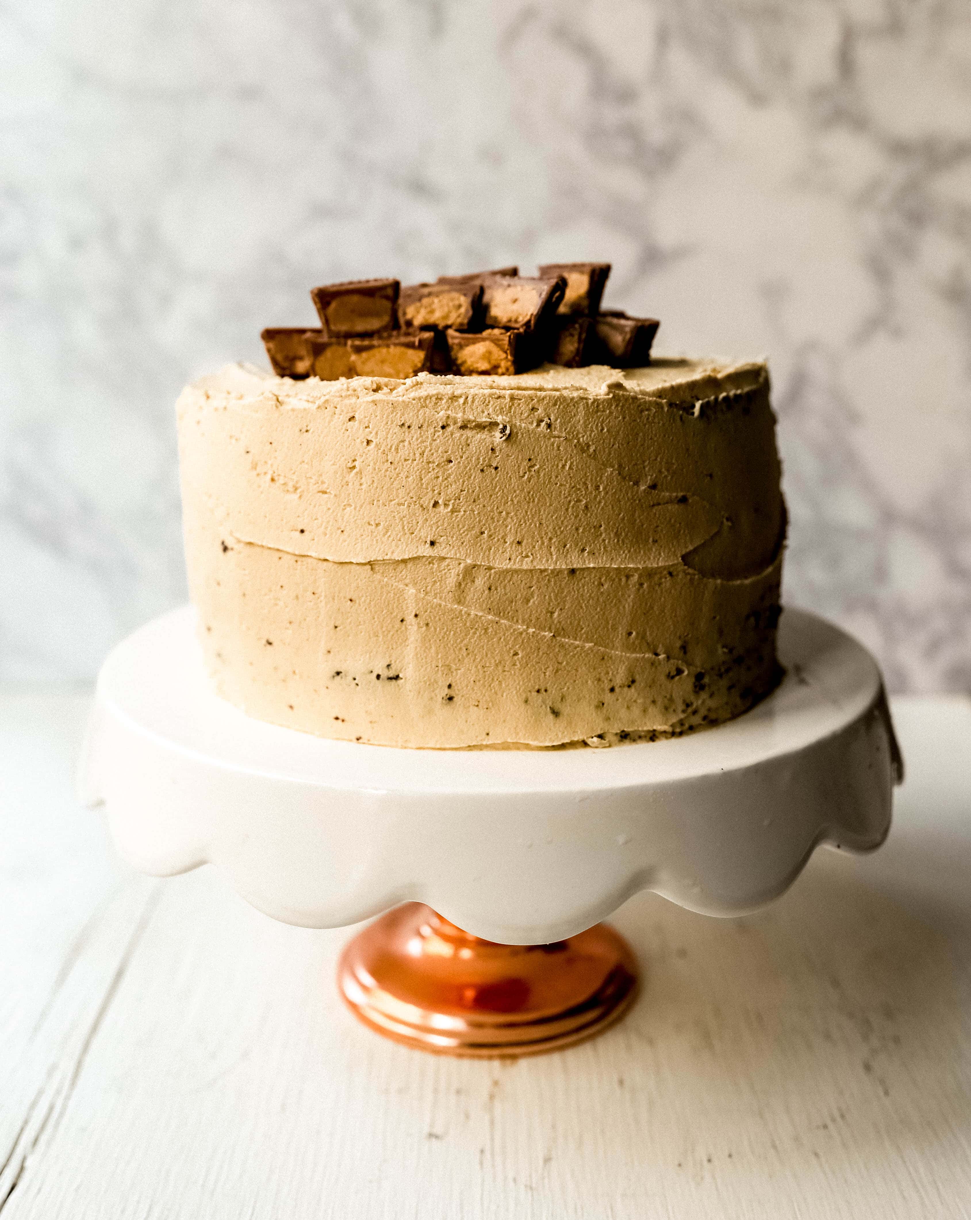 Chocolate Cake with Peanut Butter Frosting A moist 5-Star Rated Chocolate Cake with Creamy Peanut Butter Frosting topped with Peanut Butter Cups. www.modernhoney.com #peanutbutter #chocolatepeanutbuttercake #chocolatecake