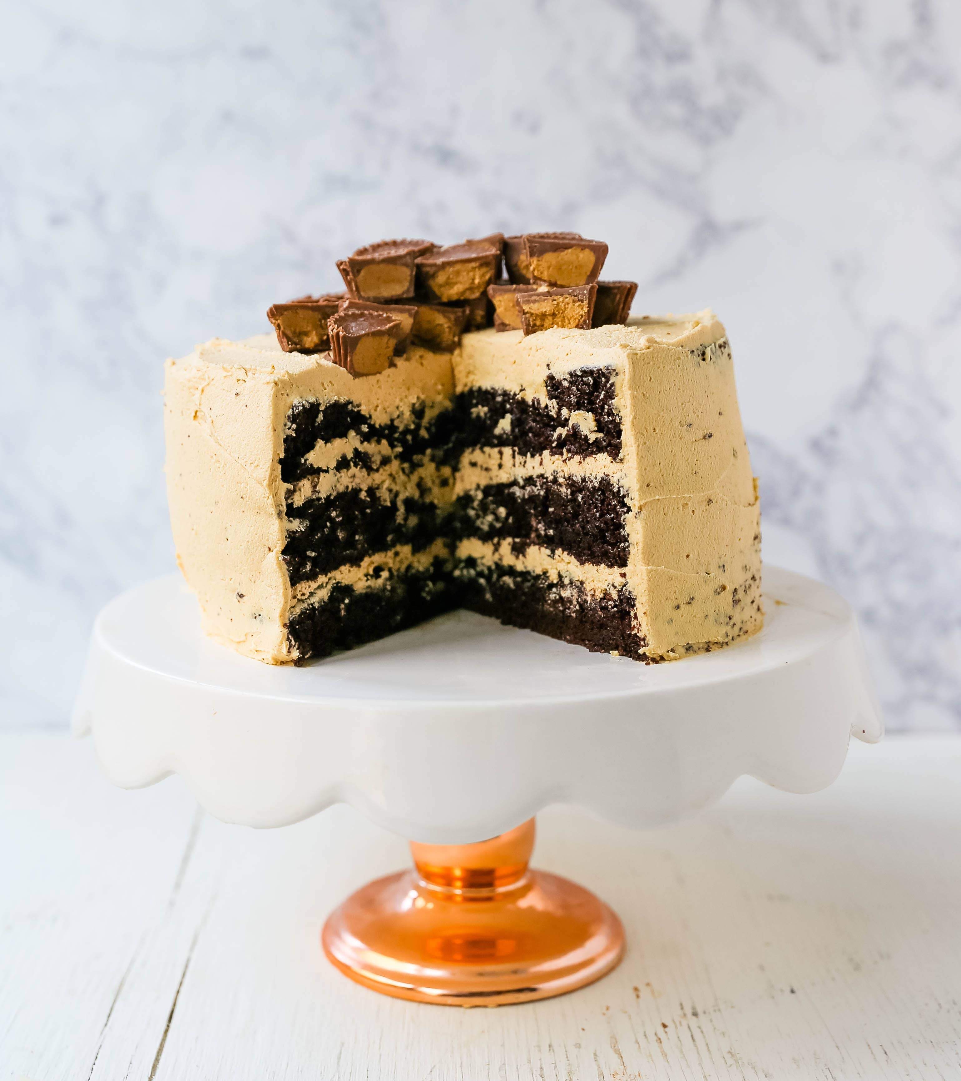 Chocolate Cake with Peanut Butter Frosting A moist 5-Star Rated Chocolate Cake with Creamy Peanut Butter Frosting topped with Peanut Butter Cups. www.modernhoney.com #peanutbutter #chocolatepeanutbuttercake #chocolatecake