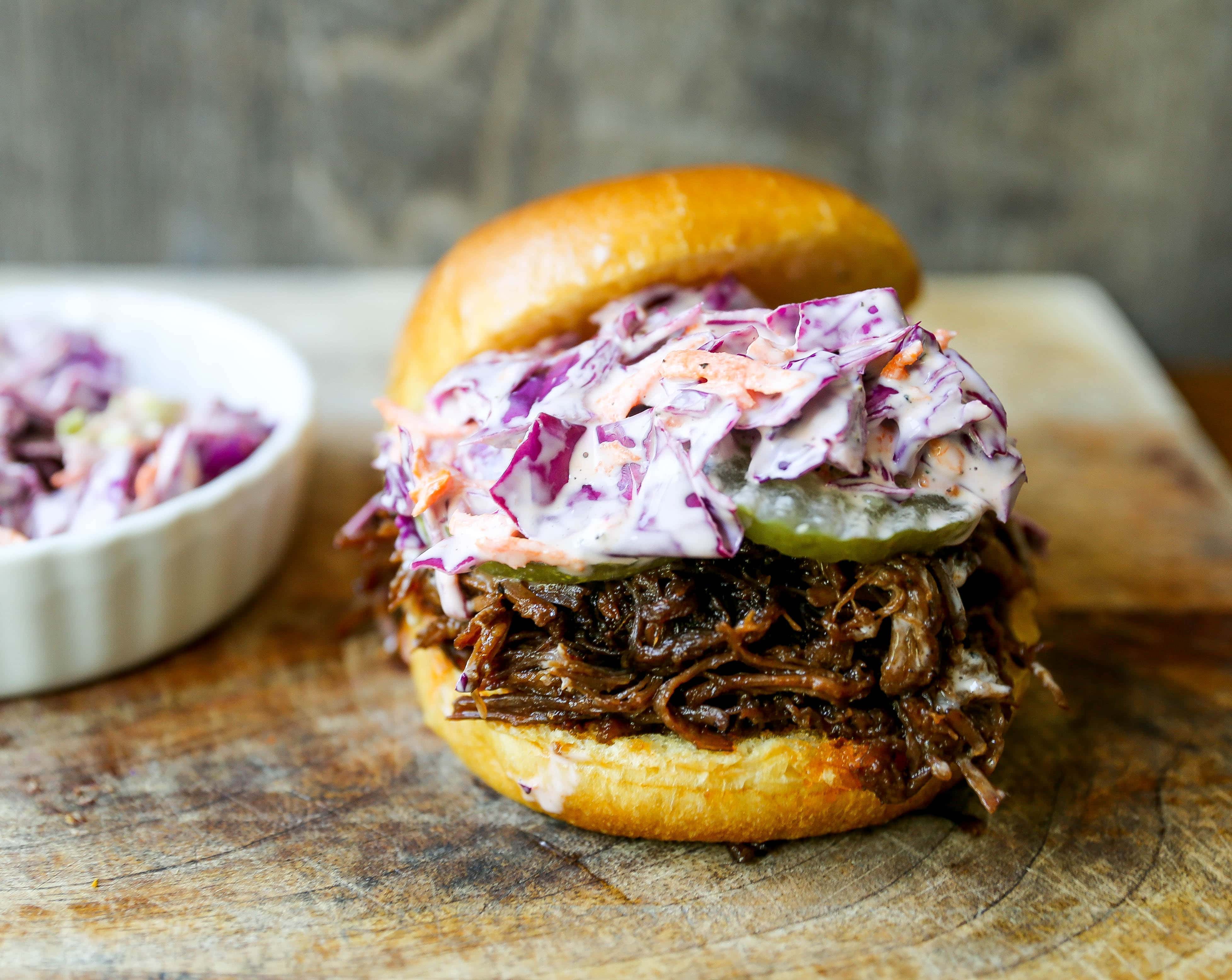 Slow Cooker BBQ Beef Sandwiches Tender seasoned slow cooked beef basted in BBQ sauce and sandwiched between brioche buns and topped with a crunchy coleslaw. www.modernhoney.com #bbqbeef #bbq #crockpot #slowcooker