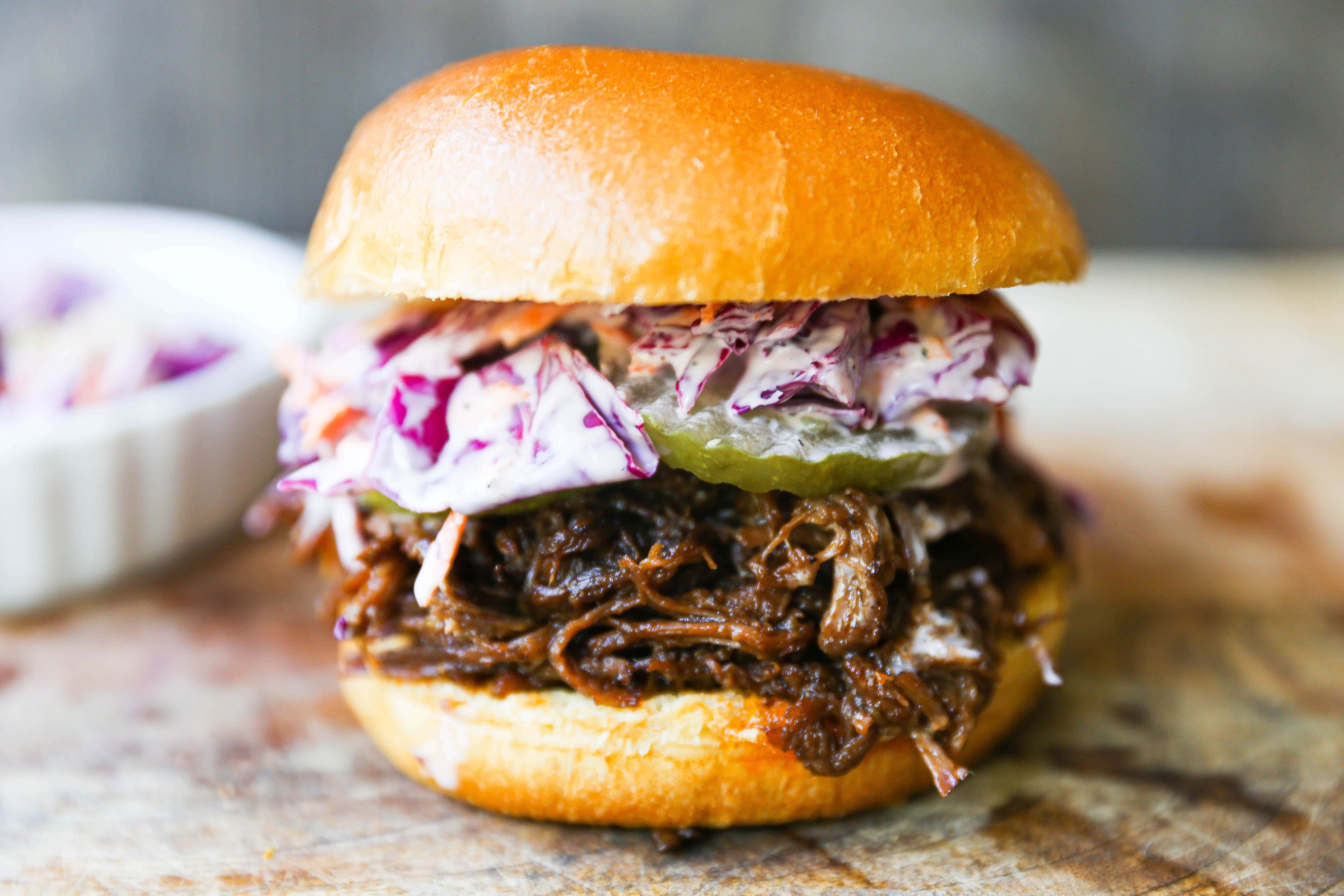 Slow Cooker BBQ Beef Sandwiches Tender seasoned slow cooked beef basted in BBQ sauce and sandwiched between brioche buns and topped with a crunchy coleslaw. www.modernhoney.com #bbqbeef #bbq #crockpot #slowcooker