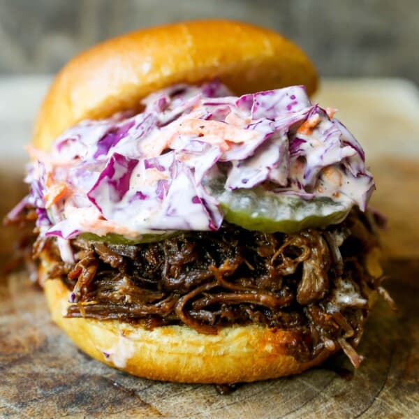 Slow Cooker BBQ Beef Sandwiches Tender seasoned slow cooked beef basted in BBQ sauce and sandwiched between brioche buns and topped with a crunchy coleslaw. www.modernhoney.com #bbqbeef #bbq #crockpot #slowcooker