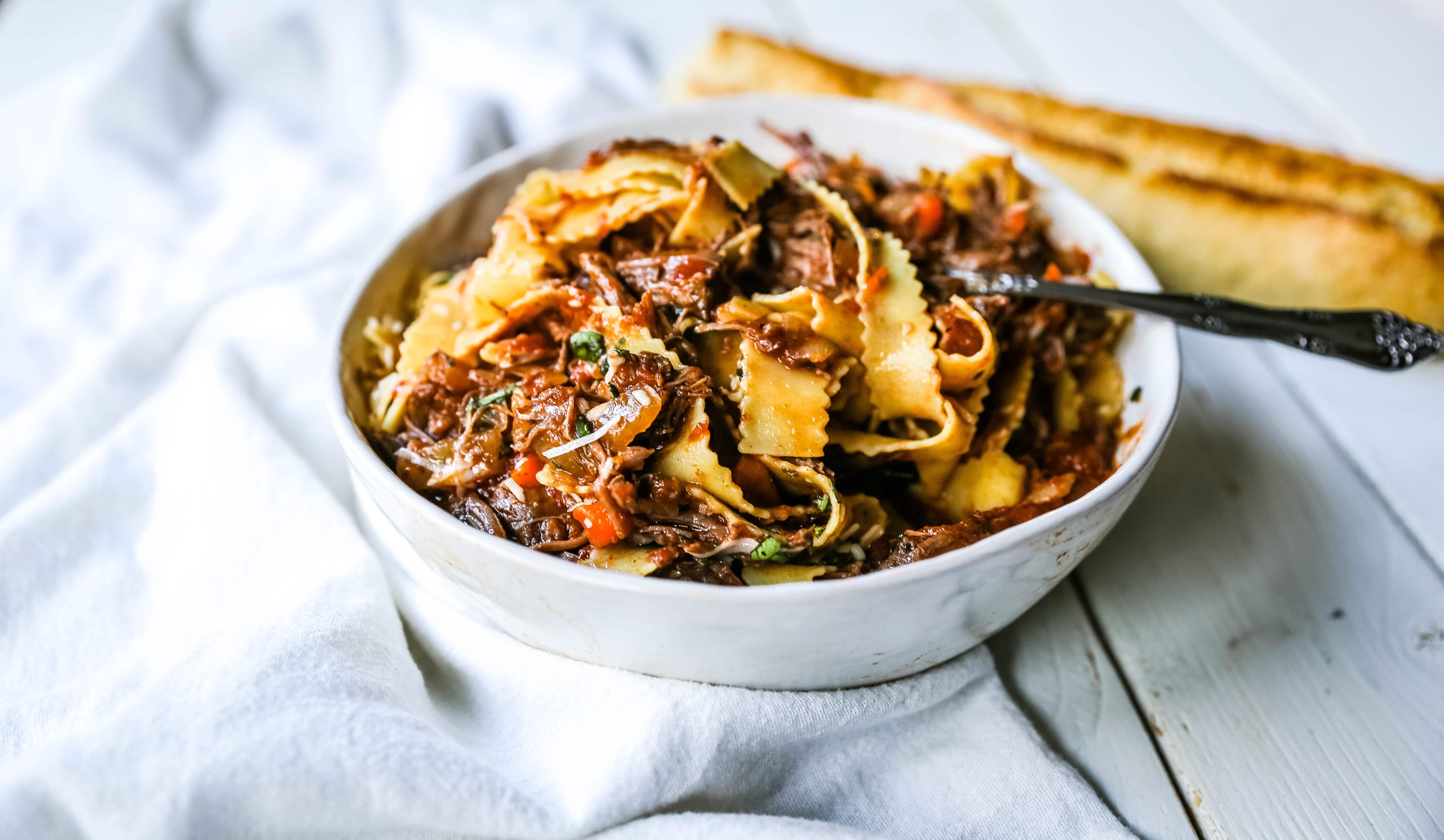 Sunday Slow Cooker Beef Ragu. Authentic Italian Beef Ragu. The ultimate comfort food! A big bowl of slow cooked, braised beef in a rich, robust tomato sauce tossed with pasta. I guarantee that you will go back for seconds! www.modernhoney.com #slowcooker #beefragu #italianfood #italian