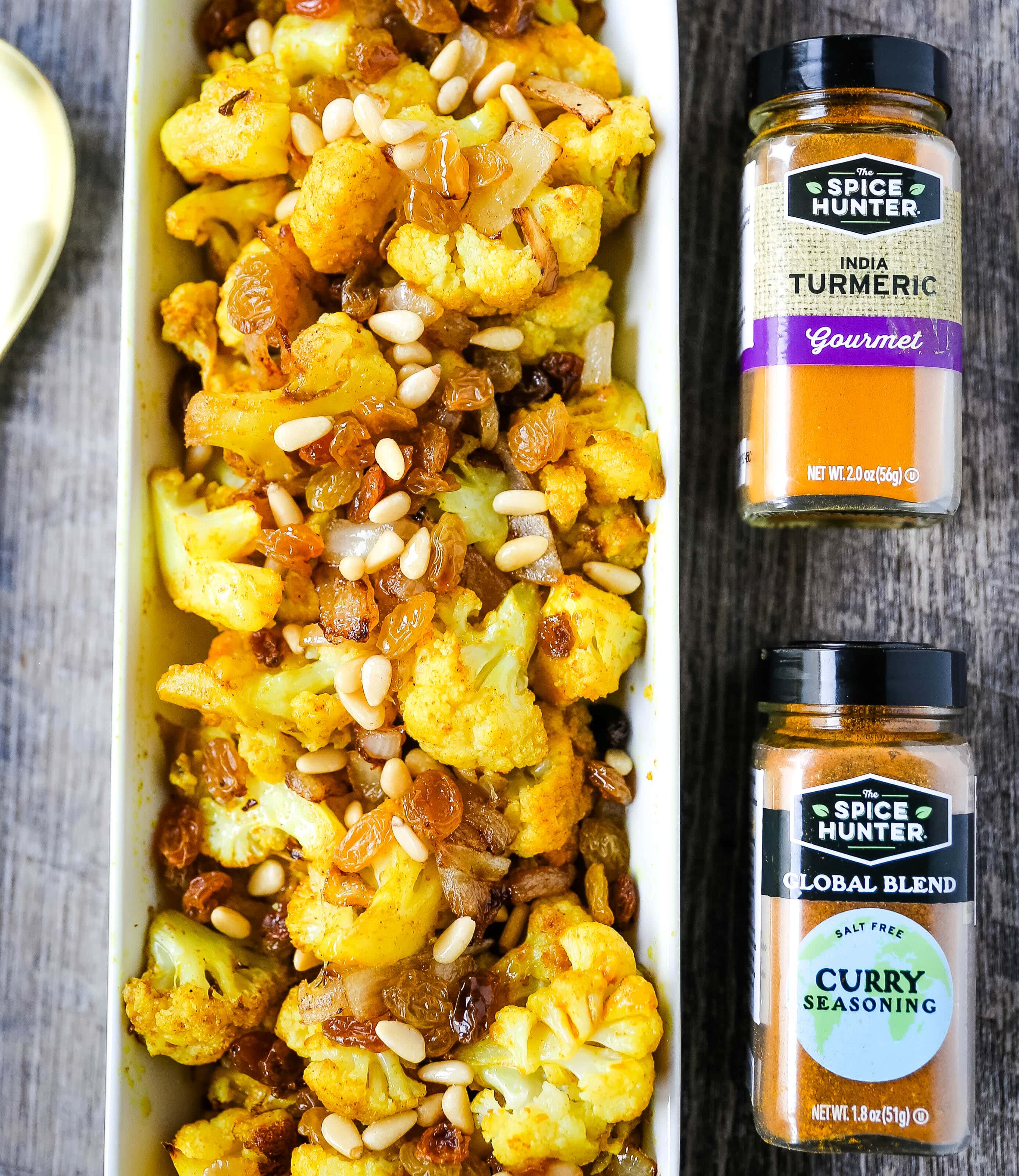 Turmeric Roasted Cauliflower Indian spiced roasted cauliflower with warm spices, caramelized onions, sweet golden raisins, and crunchy pine nuts. A flavorful, healthy side dish perfect for any occasion! www.modernhoney.com #cauliflower #sidedish #roastedvegetables #indianfood 