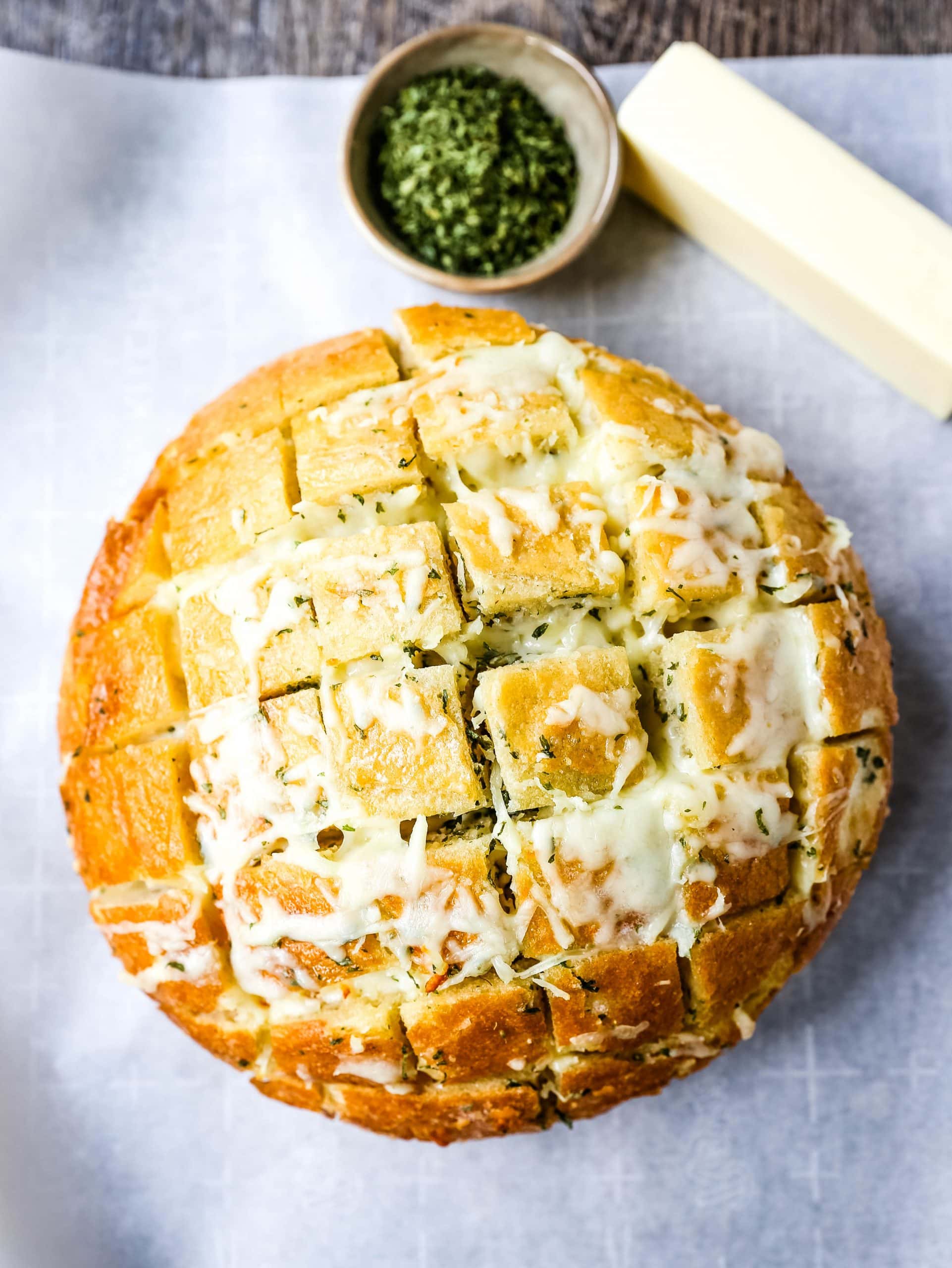 Cheesy Pull-Apart Garlic Bread Warm sourdough bread baked with garlic butter, melted mozzarella cheese, and spices. The best pull-apart garlic cheese bread! www.modernhoney.com #garlicbread #cheesebread #garliccheesebread