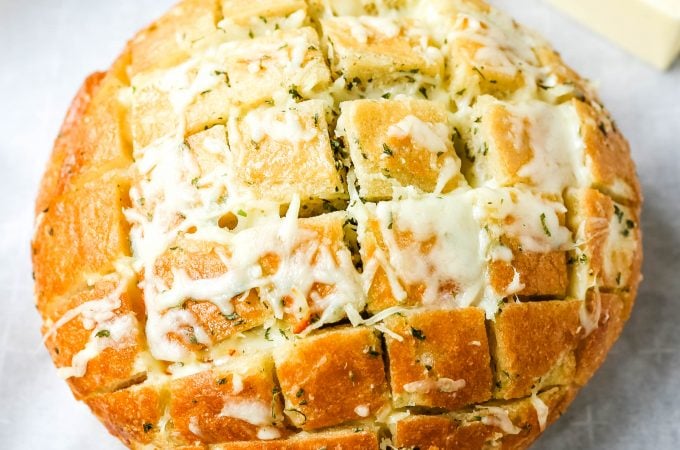 Cheesy Pull-Apart Garlic Bread Warm sourdough bread baked with garlic butter, melted mozzarella cheese, and spices. The best pull-apart garlic cheese bread! www.modernhoney.com #garlicbread #cheesebread #garliccheesebread