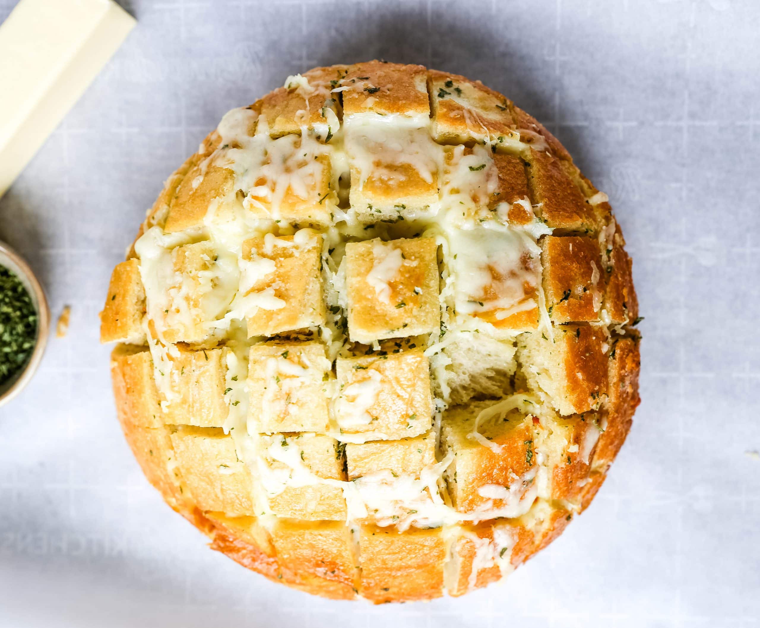 Cheesy Pull-Apart Garlic Bread Warm sourdough bread baked with garlic butter, melted mozzarella cheese, and spices. The best pull-apart garlic cheese bread! www.modernhoney.com #garlicbread #cheesebread #garliccheesebread