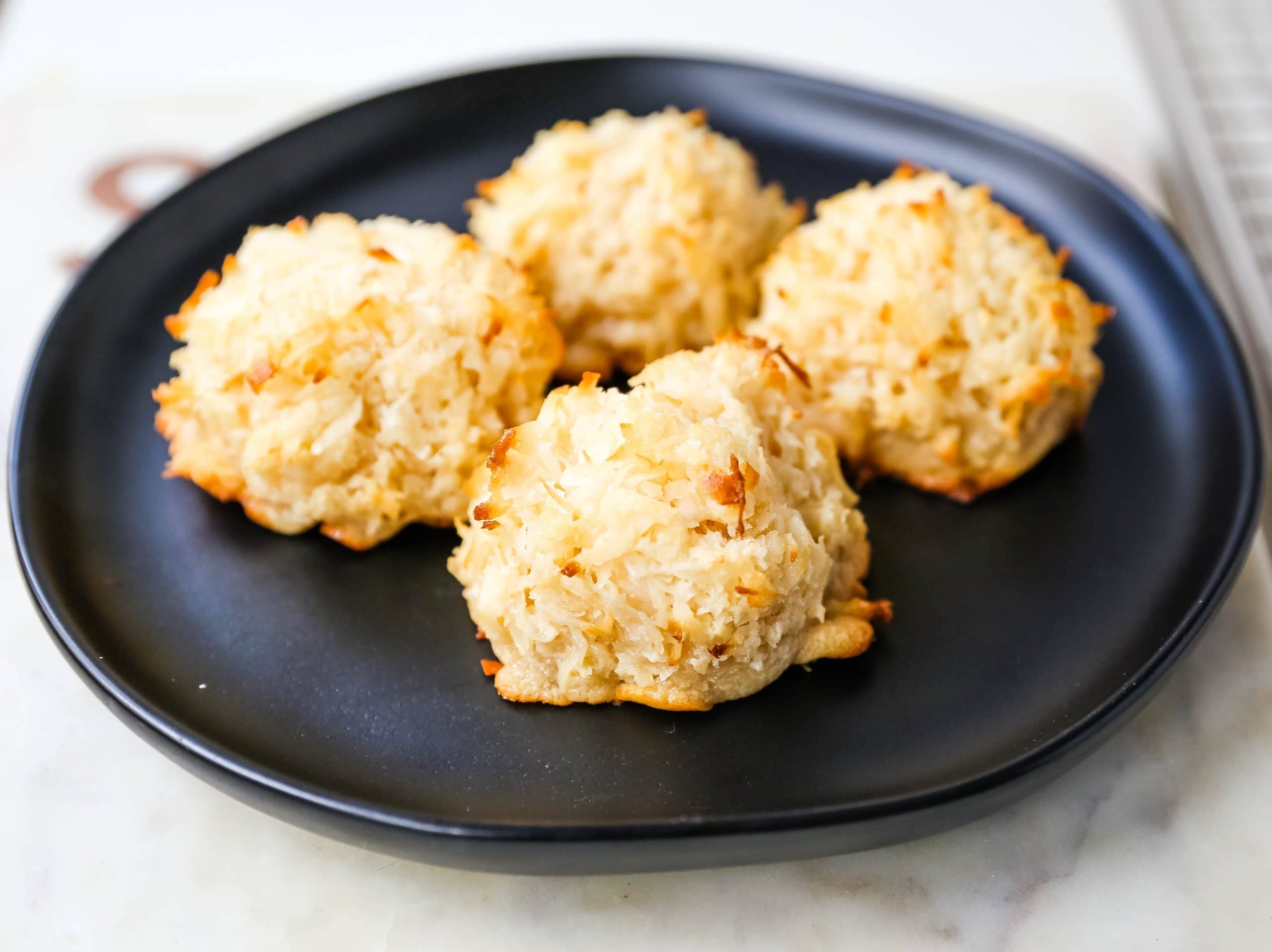 The Best Coconut Macaroons. Soft chewy sweet coconut macaroons are the perfect gluten-free cookie. How to make the perfect coconut macaroons dipped in dark chocolate. www.modernhoney.com #macaroons #coconutmacaroons #macaroon #christmascookie #christmascookies