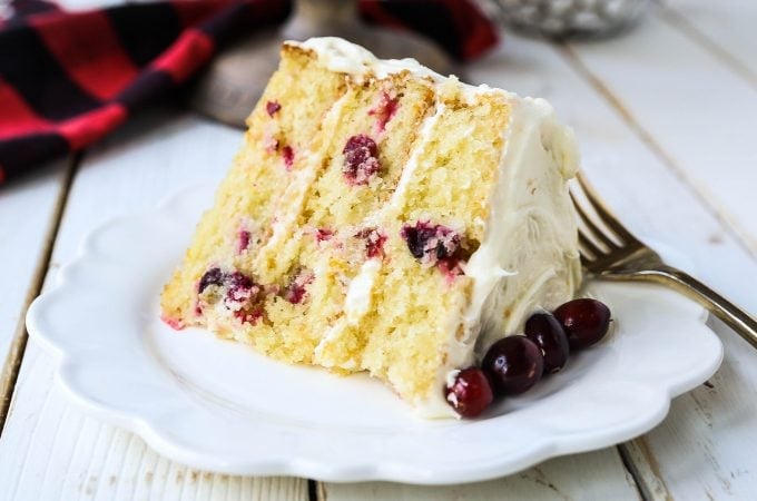 Cranberry Orange Cake. A moist orange zest cake with fresh cranberries with a sweet cream cheese orange frosting. A sweet yet tart holiday cake. www.modernhoney.com #cranberry #cranberrycake #cranberryorange #cranberryorangecake