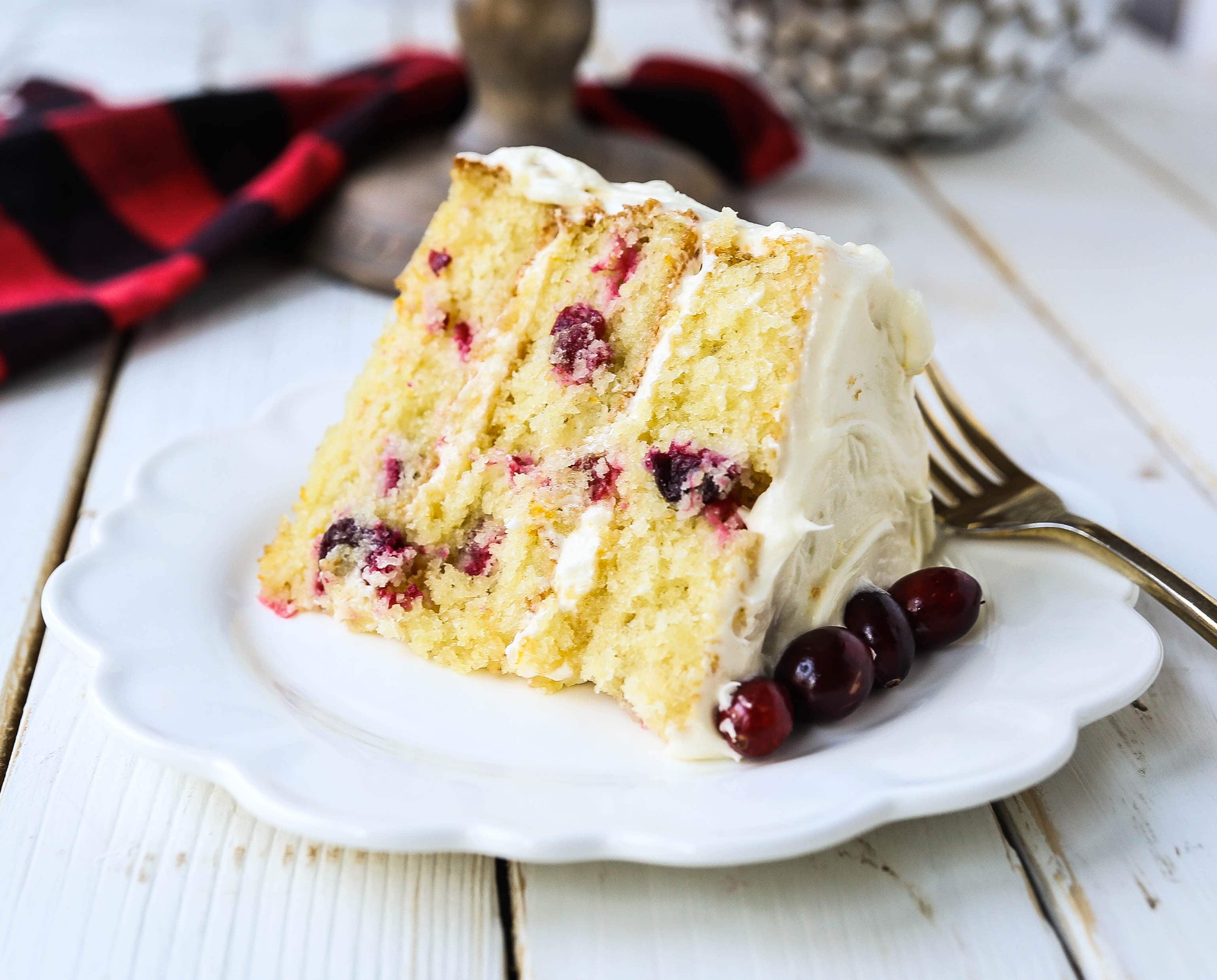 Cranberry Orange Cake. A moist orange zest cake with fresh cranberries with a sweet cream cheese orange frosting. A sweet yet tart holiday cake. www.modernhoney.com #cranberry #cranberrycake #cranberryorange #cranberryorangecake