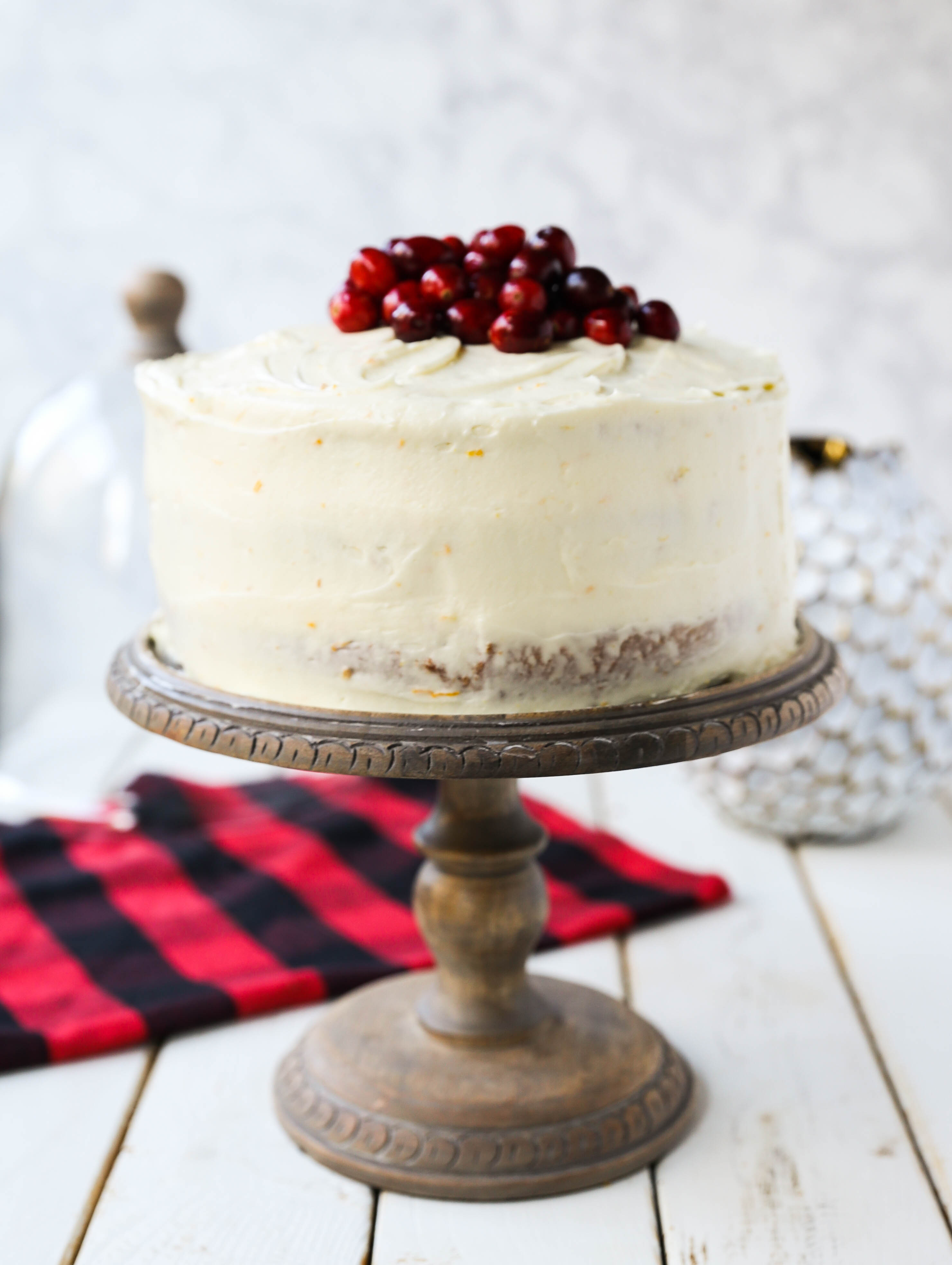 Cranberry Orange Cake. A moist orange zest cake with fresh cranberries with a sweet cream cheese orange frosting. A sweet yet tart holiday cake. www.modernhoney.com #cranberry #cranberrycake #cranberryorange #cranberryorangecake