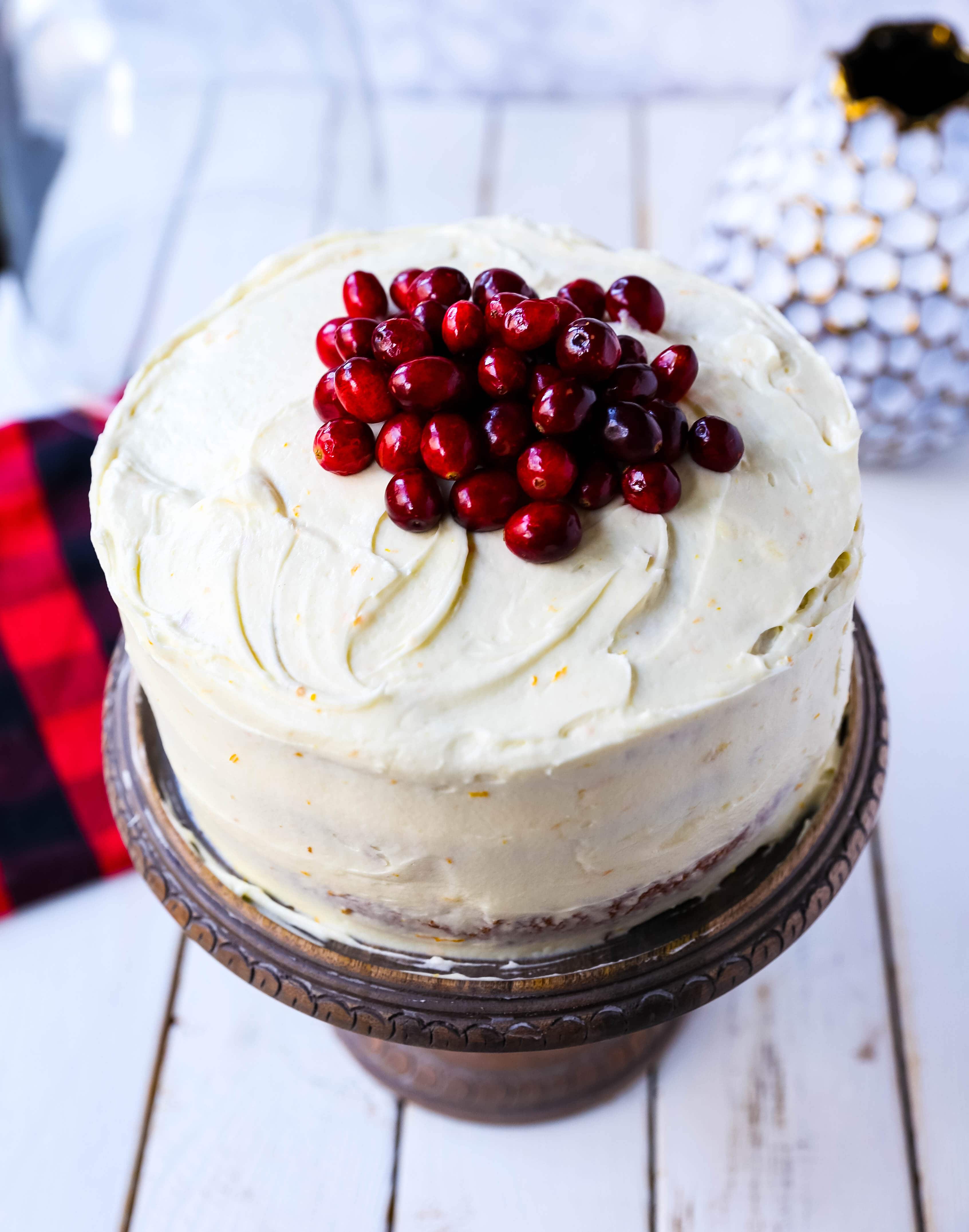 Cranberry Orange Cake. A moist orange zest cake with fresh cranberries with a sweet cream cheese orange frosting. A sweet yet tart holiday cake. www.modernhoney.com #cranberry #cranberrycake #cranberryorange #cranberryorangecake