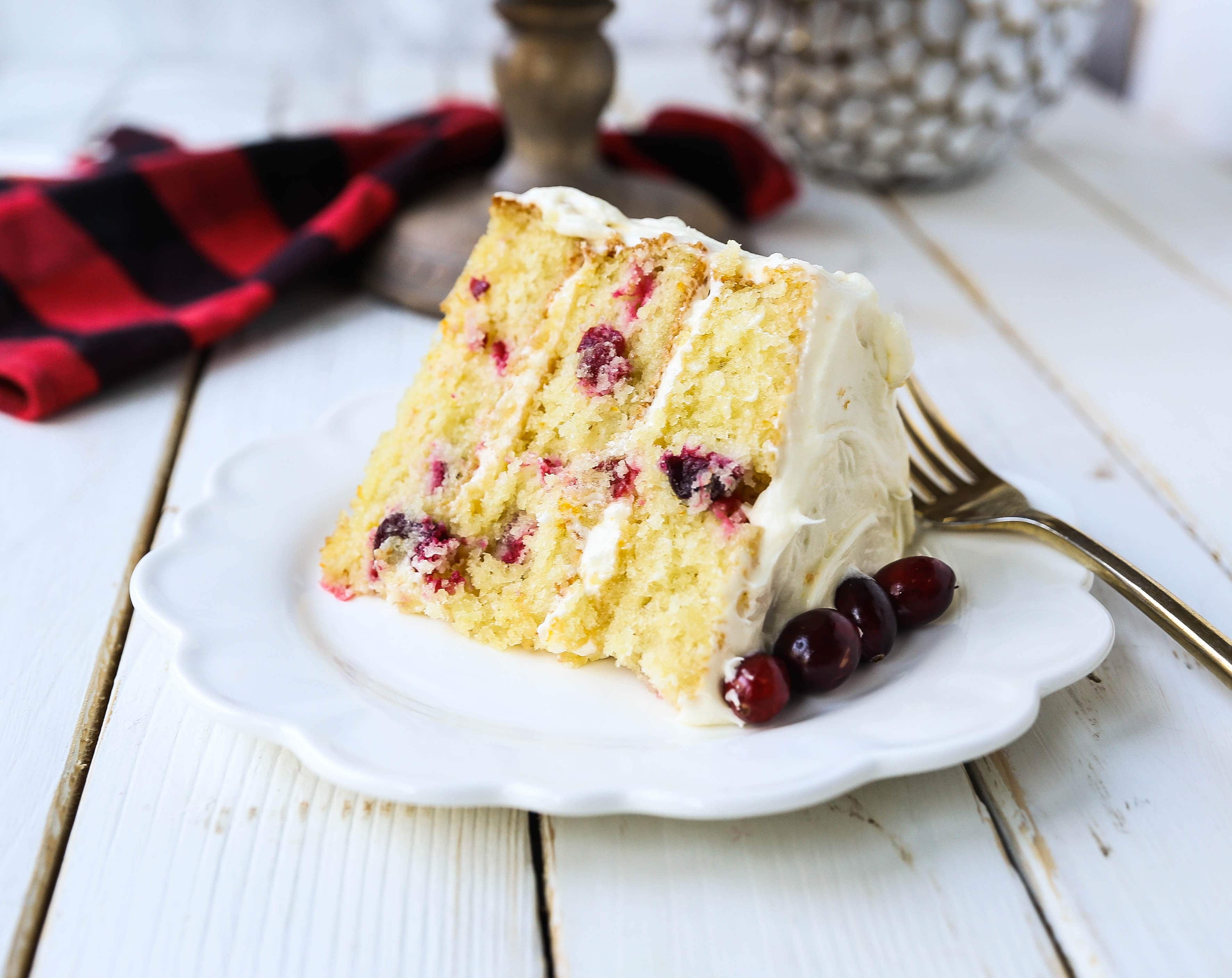 Cranberry Orange Cake. A moist orange zest cake with fresh cranberries with a sweet cream cheese orange frosting. A sweet yet tart holiday cake. www.modernhoney.com #cranberry #cranberrycake #cranberryorange #cranberryorangecake