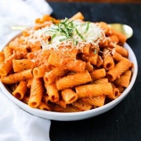 Creamy Roasted Red Pepper Pasta A creamy roasted red pepper and tomato basil sauce with garlic and heavy cream all tossed together with pasta and topped with parmesan cheese. A flavorful robust pasta dish! www.modernhoney.com #pasta #italian #italianfood