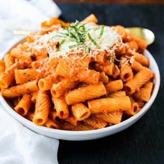 Creamy Roasted Red Pepper Pasta  A creamy roasted red pepper and tomato basil sauce with garlic and heavy cream all tossed together with pasta and topped with parmesan cheese. A flavorful robust pasta dish! www.modernhoney.com #pasta #italian #italianfood