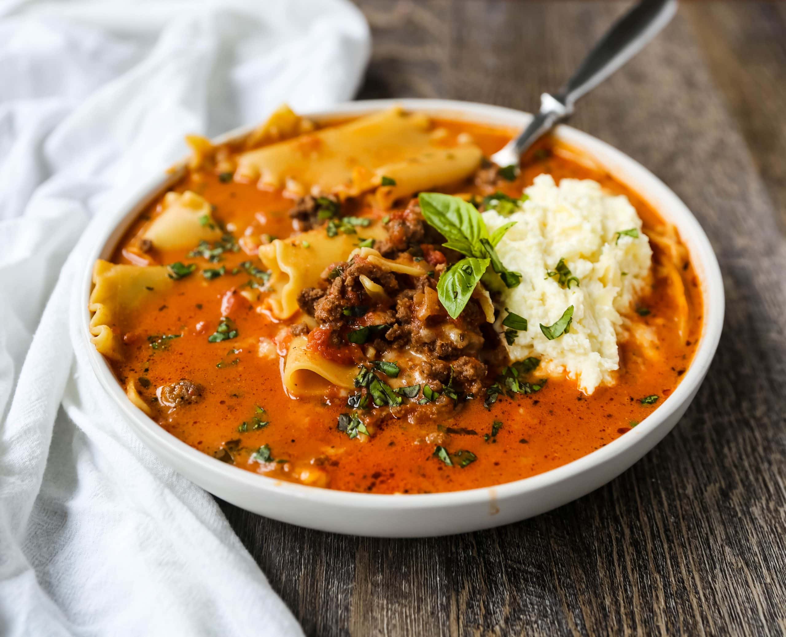 Lasagna Soup. A hearty beef lasagna soup with fresh ricotta cheese, mozzarella, and parmesan cheeses and fresh herbs. An Italian classic made into a comforting soup! #lasagnasoup #soup #soups #comfortfood