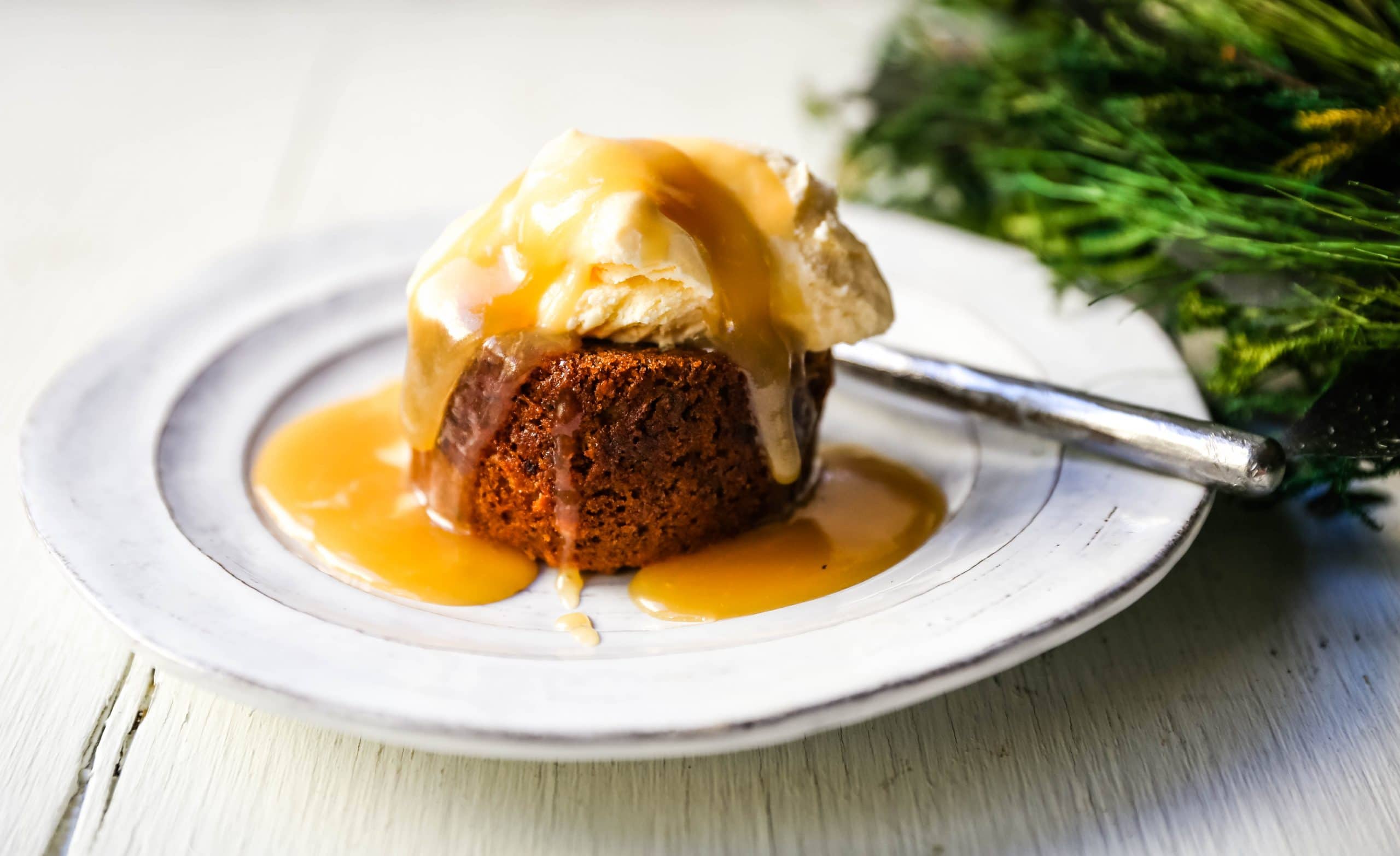 Sticky Toffee Pudding. A famous English dessert with a moist sponge cake covered in a homemade caramel toffee sauce and vanilla ice cream. The perfect Christmas dessert or holiday dessert recipe. A Christmas traditional dessert. www.modernhoney.com #stickytoffeepudding #toffeepudding #stickypudding #datecake