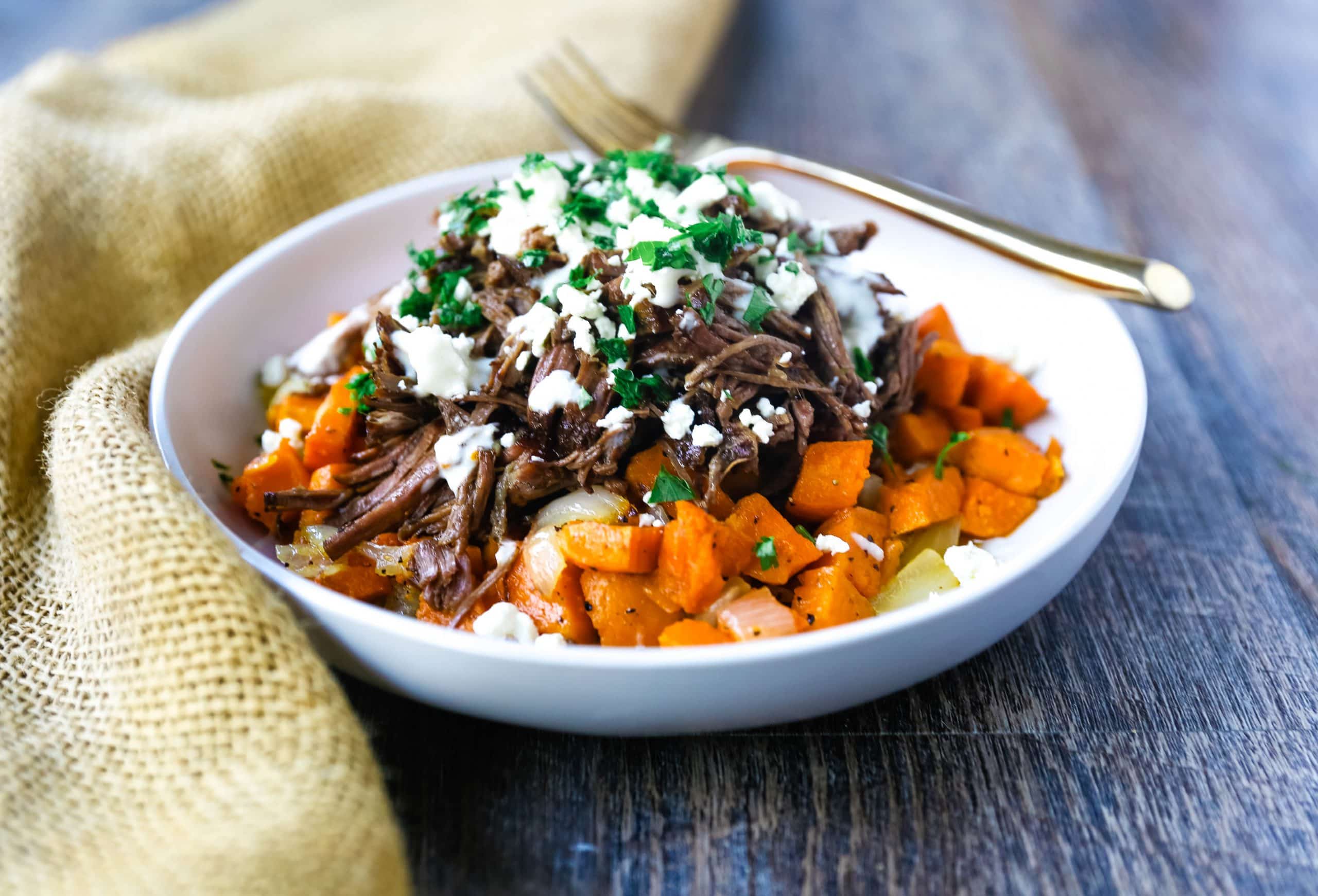 Braised Beef and Sweet Potato Hash Bowl. Tender braised beef on top of a sweet potato onion hash and topped with feta cheese and herbs. www.modernhoney.com #bowl #bowls #dinner