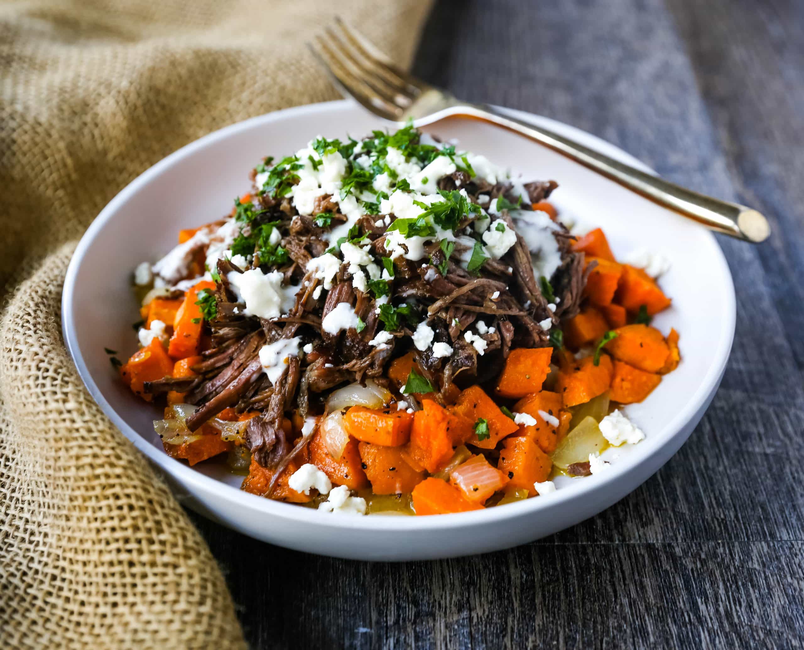 Braised Beef and Sweet Potato Hash Bowl. Tender braised beef on top of a sweet potato onion hash and topped with feta cheese and herbs. www.modernhoney.com #bowl #bowls #dinner