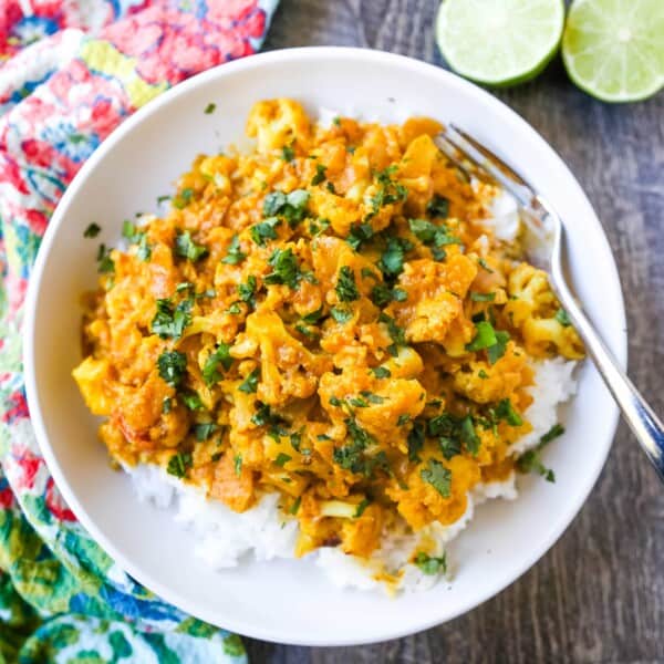 Coconut Cauliflower Curry A rich coconut curry broth with onion, garlic, cauliflower, ginger, Indian spices in coconut milk. Flavorful vegan meal and you won’t even miss the meat! www.modernhoney.com #curry #cauliflower #cauliflowercurry #indianfood