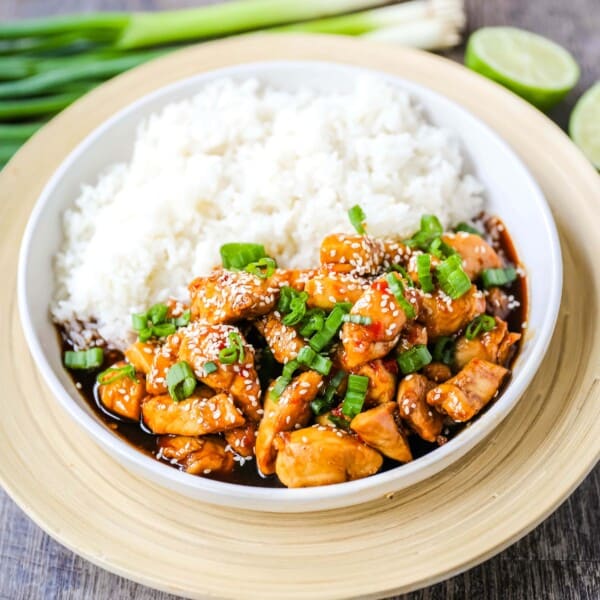 Asian Sticky Chicken Tender chicken sauteed in a sticky sweet and tangy Asian sauce served with creamy coconut rice. A quick and easy 20-minute dinner! www.modernhoney.com #asianfood #chinesefood #stickychicken #chicken