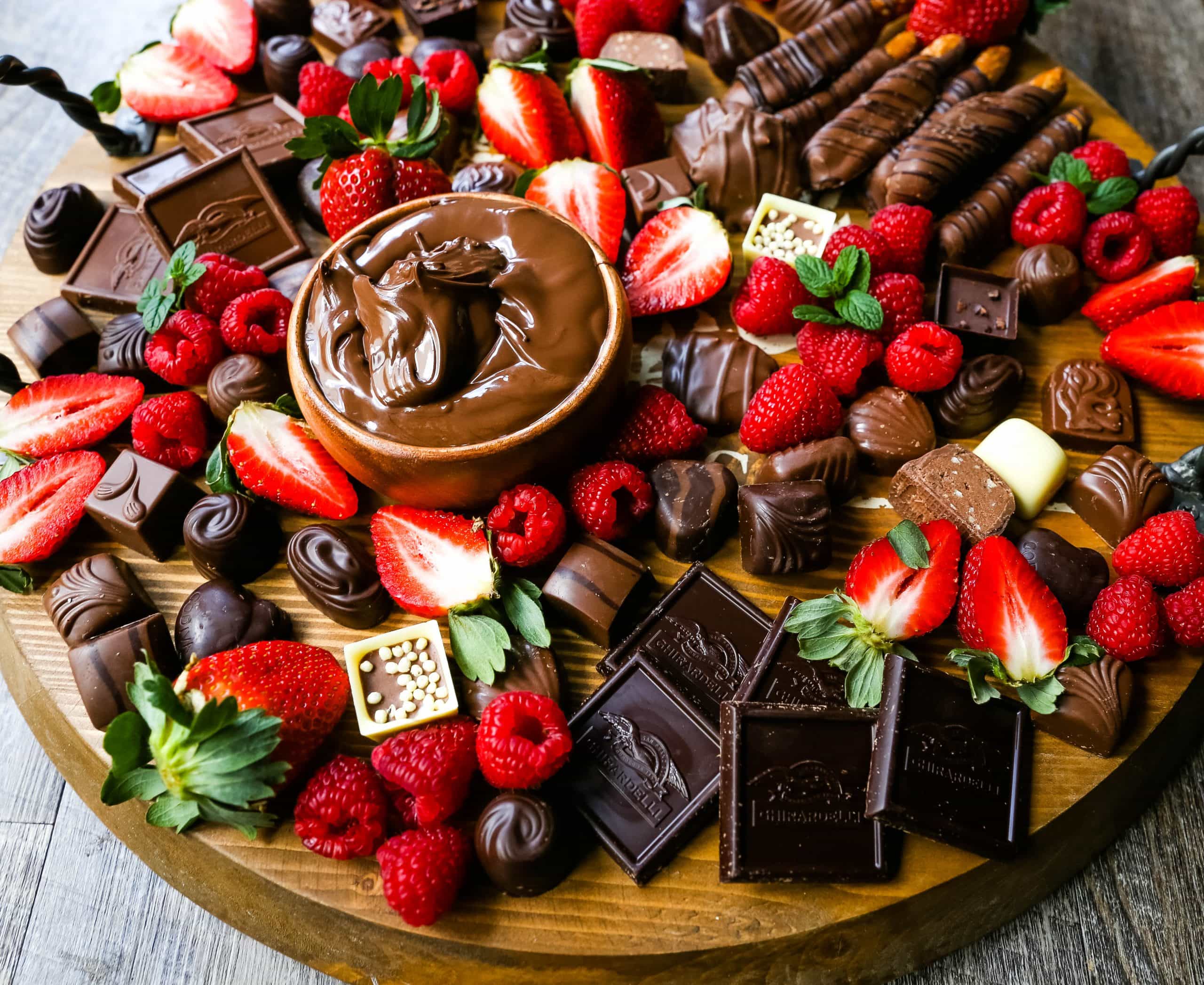 Chocolate Dessert Board A decadent chocolate board with an assortment of chocolate truffles, milk chocolate, dark chocolate hearts, chocolate covered pretzels, Nutella, berries, and more! www.modernhoney.com #chocolate #valentinesday #chocolateboard #dessert #desserts #chocolatedessert